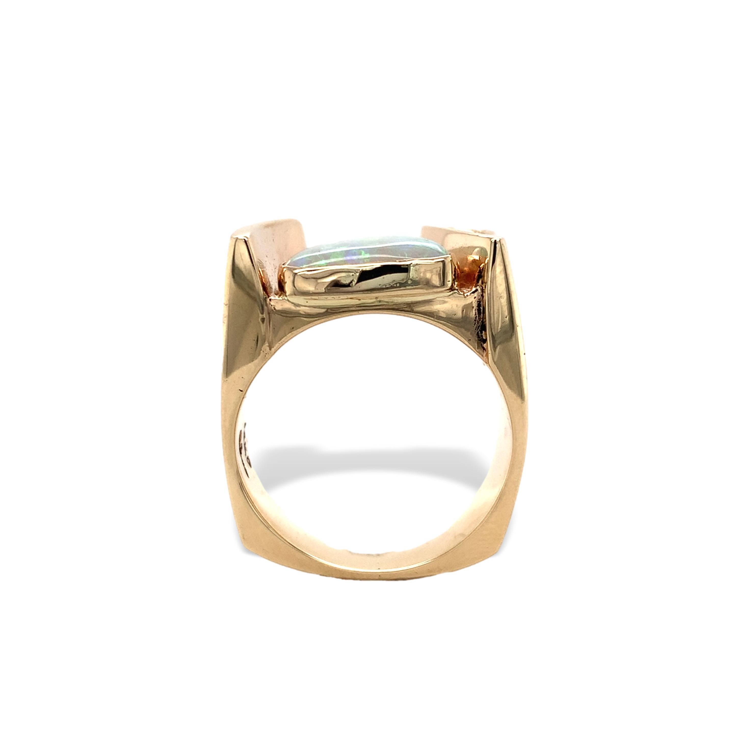 Anello moderno e personalizzato in oro giallo 14K con opale australiano.  C'è una particolare forma triangolare cabochon di opale naturale estratto dalla terra con giochi di colore multipli, tra cui il rosso-rosa. L'opale è incastonato e misura