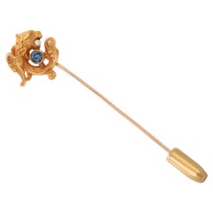 Broche poisson en or jaune 14 carats enroulé de façon complexe avec saphir dans sa bouche