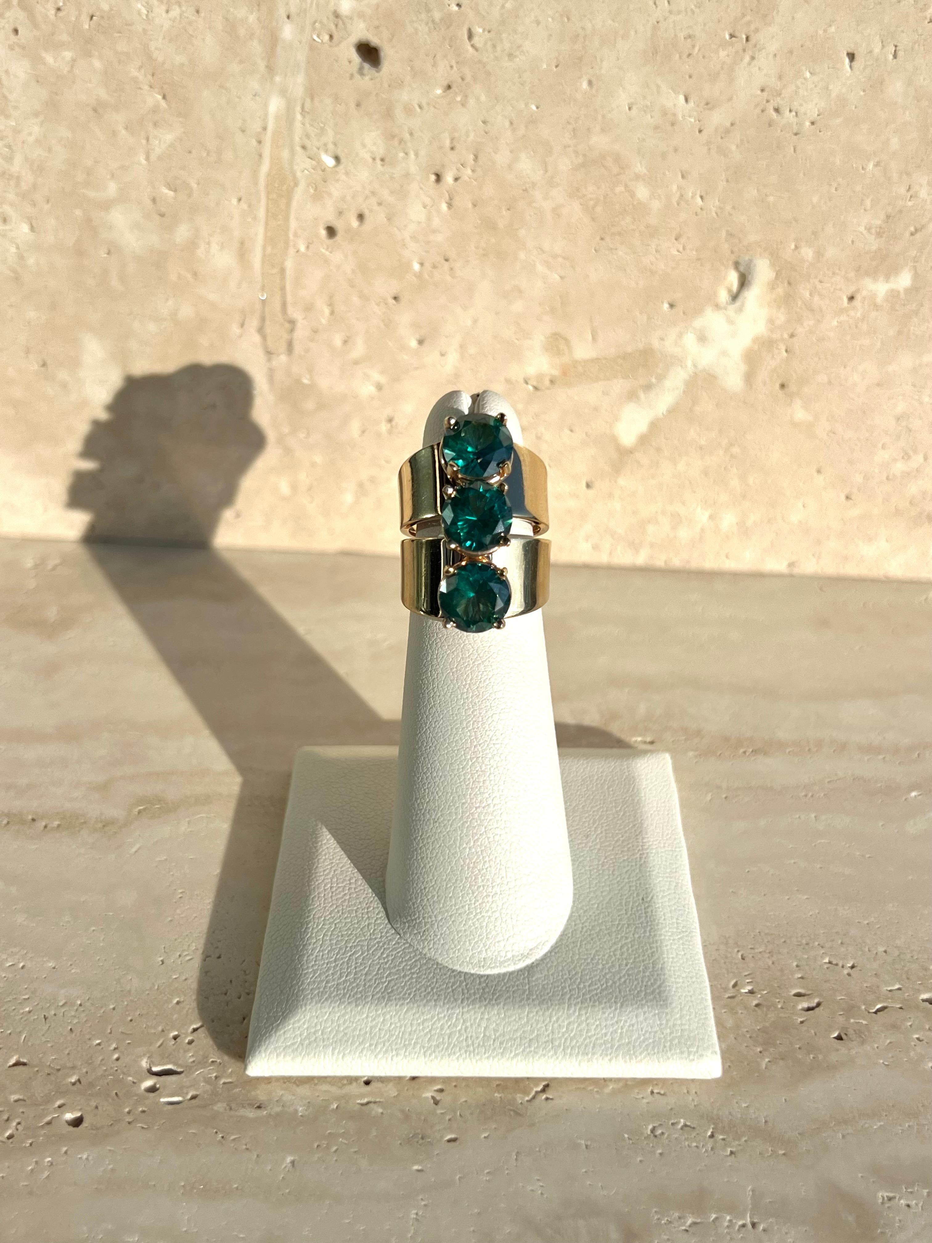 The vintage ring of a lifetime. A solid 14k gold triple stone ring made in Italy with three synthetic green stones in vertical arrangement. Excellent condition and packaged in custom Series of Eleven packaging. 

Size 4.5 - original stamps on