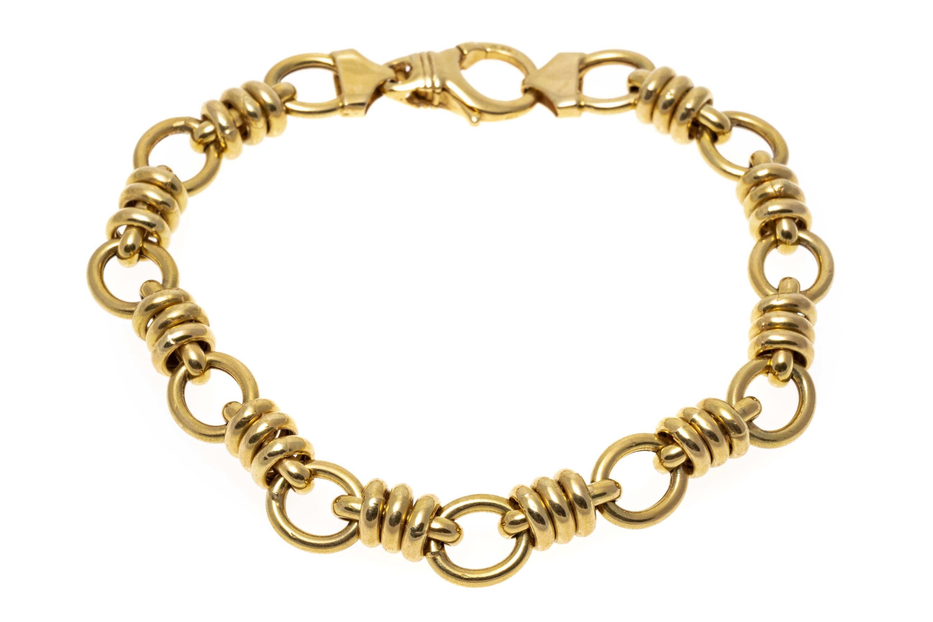 Designed in Italy, this 14K yellow gold bracelet presents an interesting design of alternating circular and bar style links. The bar style links are each wrapped in gold rings. Large lobster claw style clasp.
Marks: 14K Italy B
Dimensions: 8 1/8