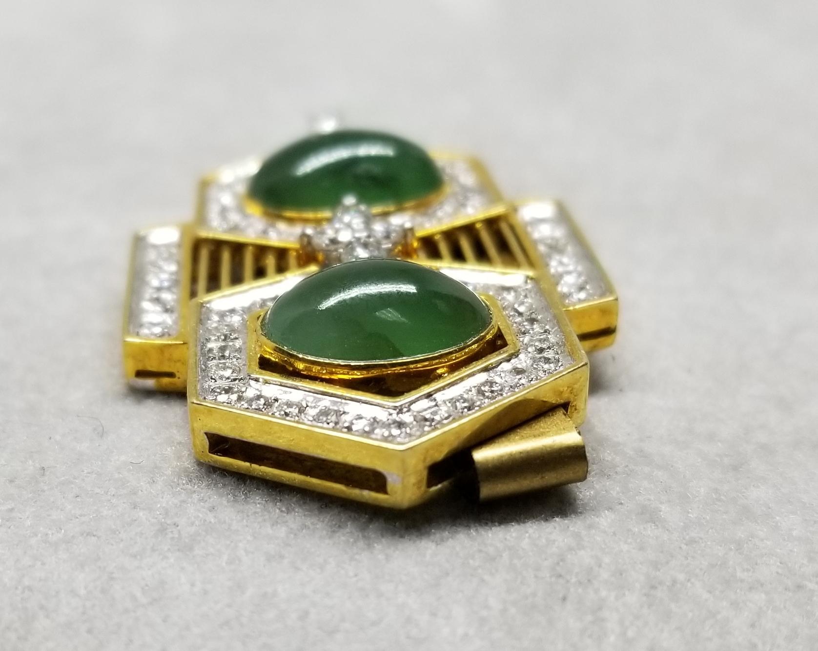 This piece of fine jewelry was designed and hand crafted by “Moshi” of New York, it was found in a vault from an estate sale and was never used.  14k yellow gold jade and diamond pendant, containing 2 oval cabochon jade and 53 round full cut