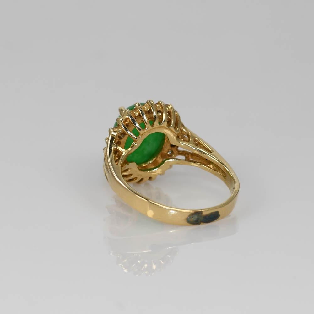 Jade and diamond ring in 14k yellow gold setting.
Stamped 14k and weighs 4 grams. 
The jade is natural not treated, excellent -high grade, solid green color, approximately 3 carats, measuring 10.14 x 7.92 x 4.42mm.
On the sides are round brilliant