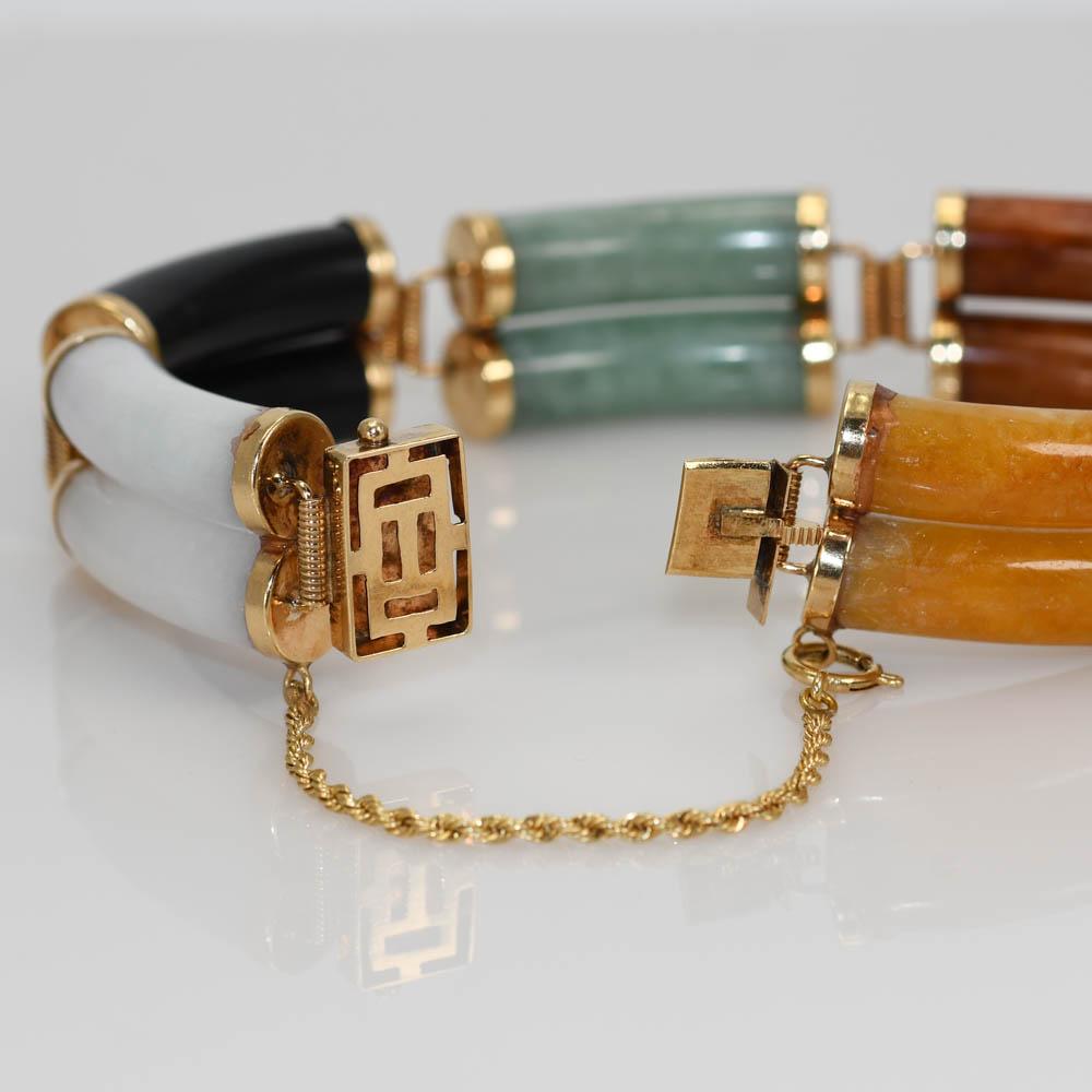 14k yellow gold and jade bracelet.
The clasp is stamped 585 14k.
The gross weight is 43.7 grams.
There are five different color of natural jade.
The bracelet measures 7 1/2 inches long and 5/8 inches wide.
There is a safety chain attached near the