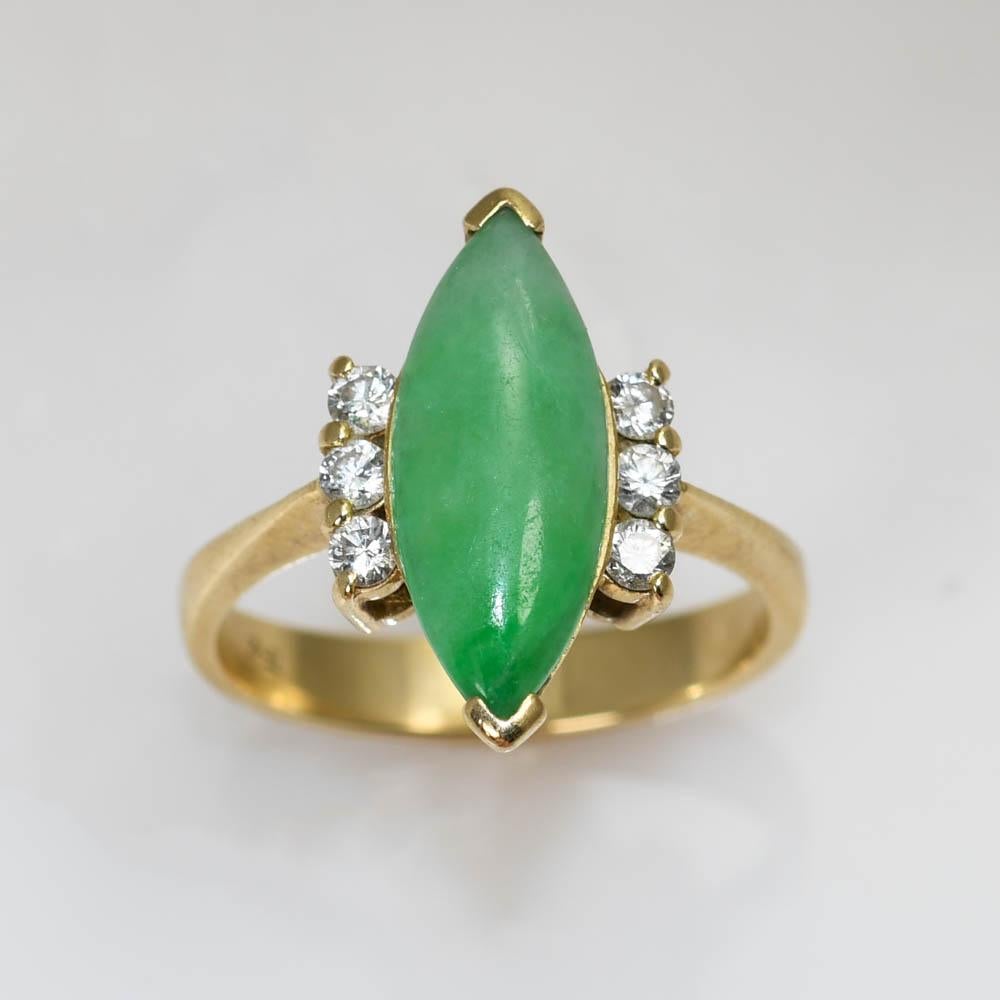 14k yellow gold Jade and Dimaond ring.
The Marquise cut Jade measures 15mm X 6.5mm. 
There are 6 Diamonds total with .18TDW.
G-H color, VS clarity.
Weighs 4gr
Size 6 1/4
