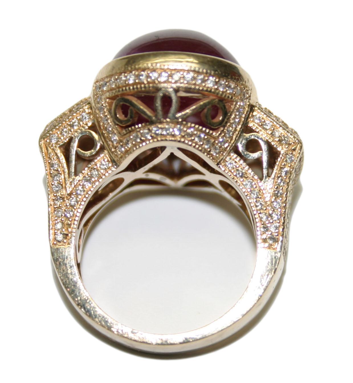 A beautiful workmanship antique design Style 14 karat yellow gold ladies ring with an overall weight of 15 grams.

The center stone is an oval shaped cabochon cut natural ruby (treated) 17 x 13.5mm, surrounded by small round brilliant diamonds