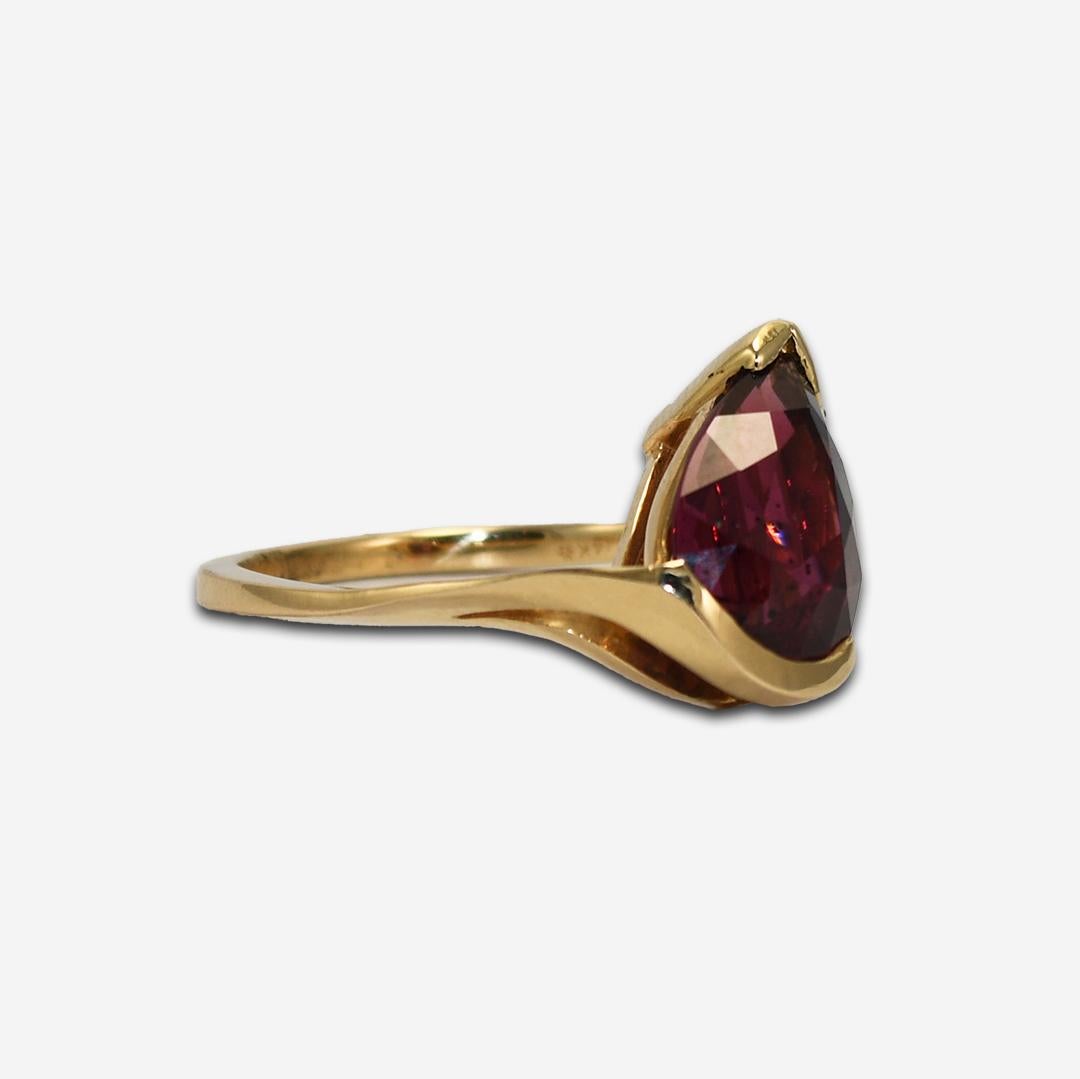 Ladies 14k yellow gold ring with Rhodolite garnet.
Marked 14k and weighs 3.5 grams.
The pear-shaped garnet is a deep purplish-red color with fancy faceting on the bottom, 3.80 carats.
The ring is in excellent condition.
The ring size is 6 1/2 and