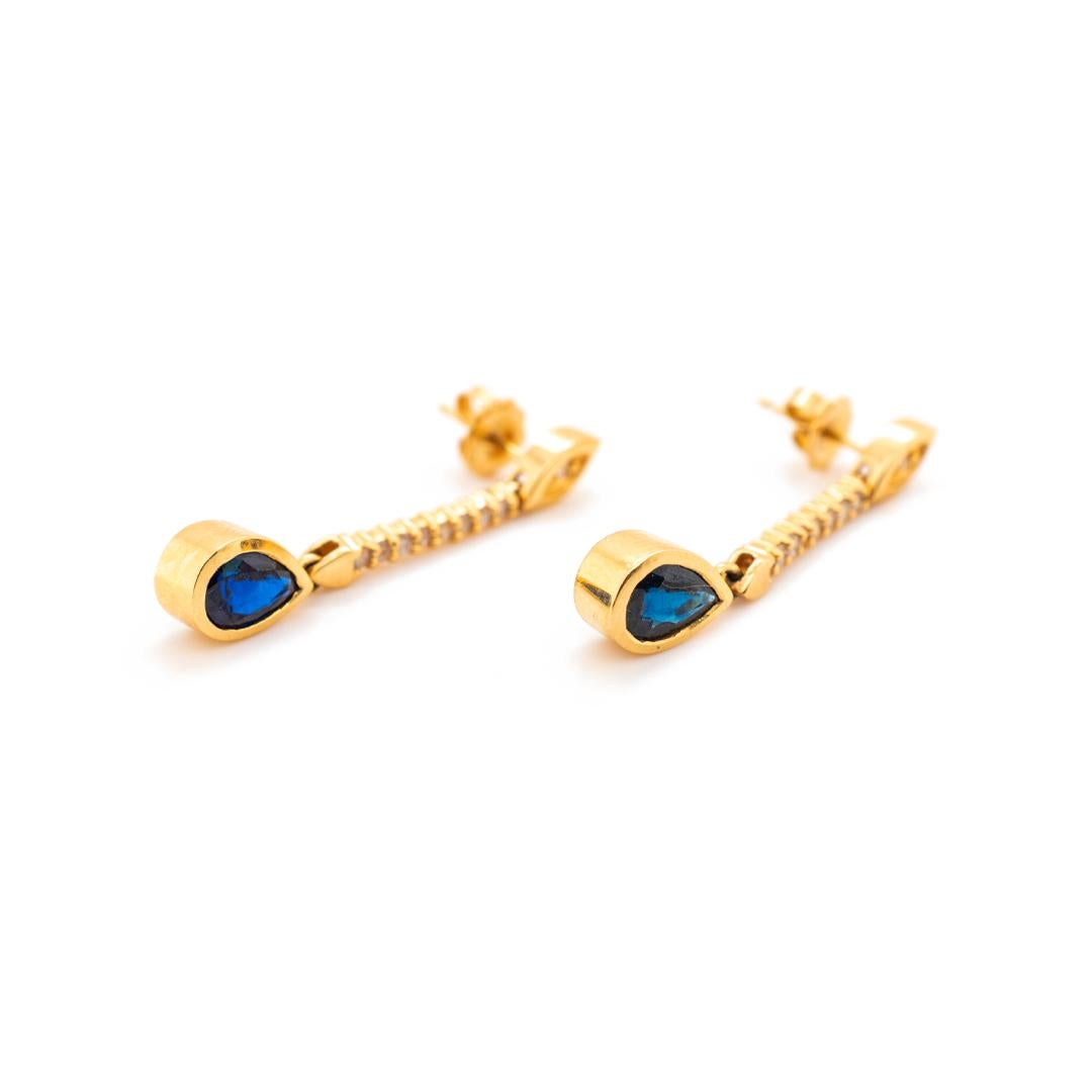 One pair of lady's custom made polished 14K yellow gold, diamond and sapphire dangle earrings with push backs. The earrings measure approximately 1.25 inches in length and weigh a total of 4.70 grams. Engraved with 