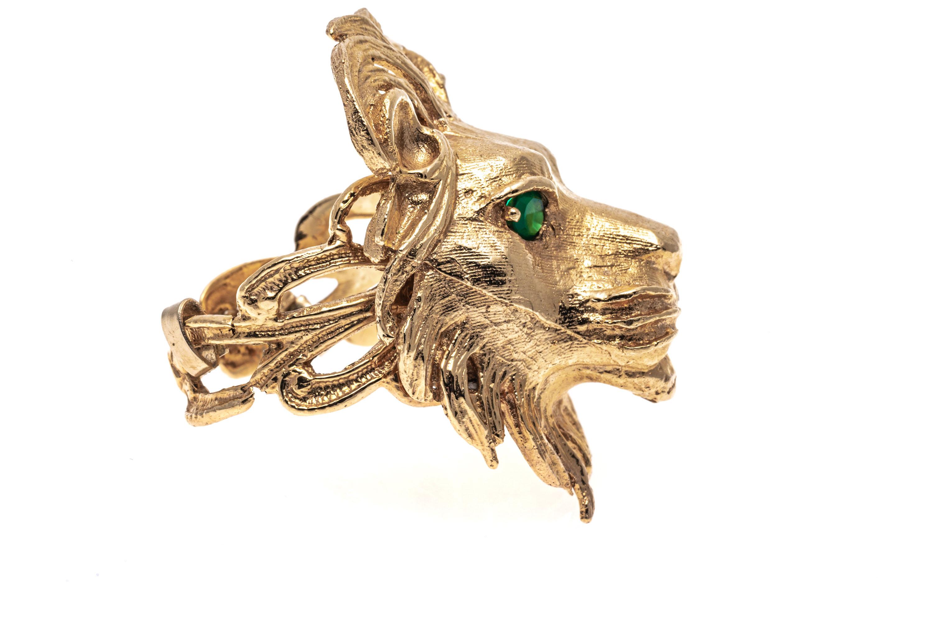 14k yellow gold ring. This classic ring is a large, matte finished, figural lions head, set with round faceted, green color green chalcedony eyes, and finished with open loop style shoulders.
Marks: 14k
Dimensions: 7/8