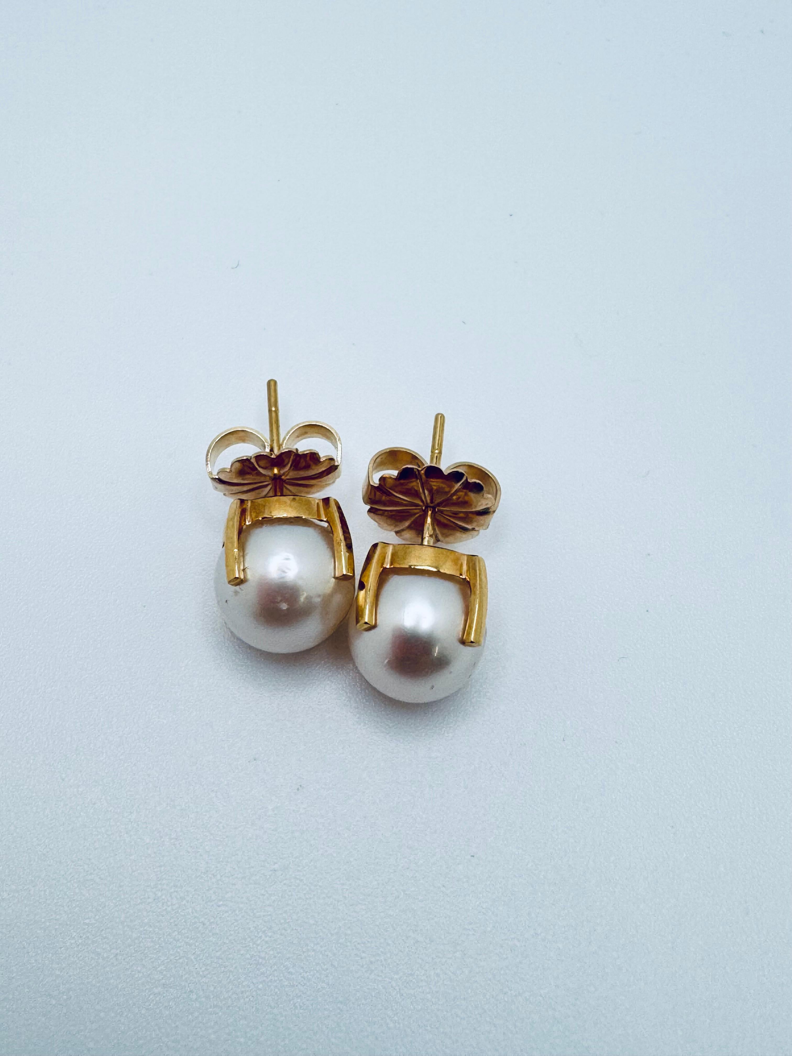 Sophistiquées et élégantes, ces grandes boucles d'oreilles en perles sont magnifiquement réalisées en or jaune 14K. Ensemble, ils présentent deux perles rondes lumineuses de 10 mm, chacune affichant un éclat radieux et une surface lisse et