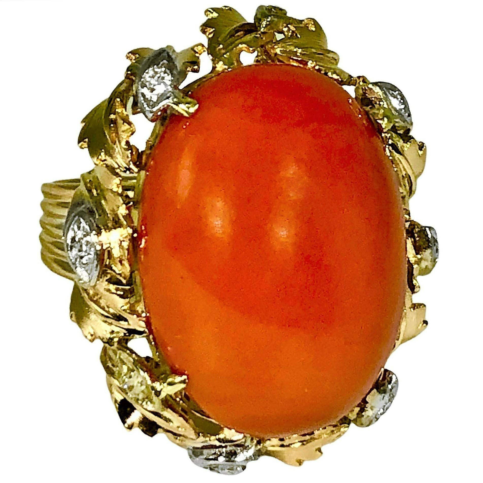 This lovely and quite large vintage fashion ring features, at it's center. a bright orange Mediterranean coral cabochon. With a measurement of 26mm by 19mm, the coral is quite significant and it has not been enhanced in any way. The mounting is