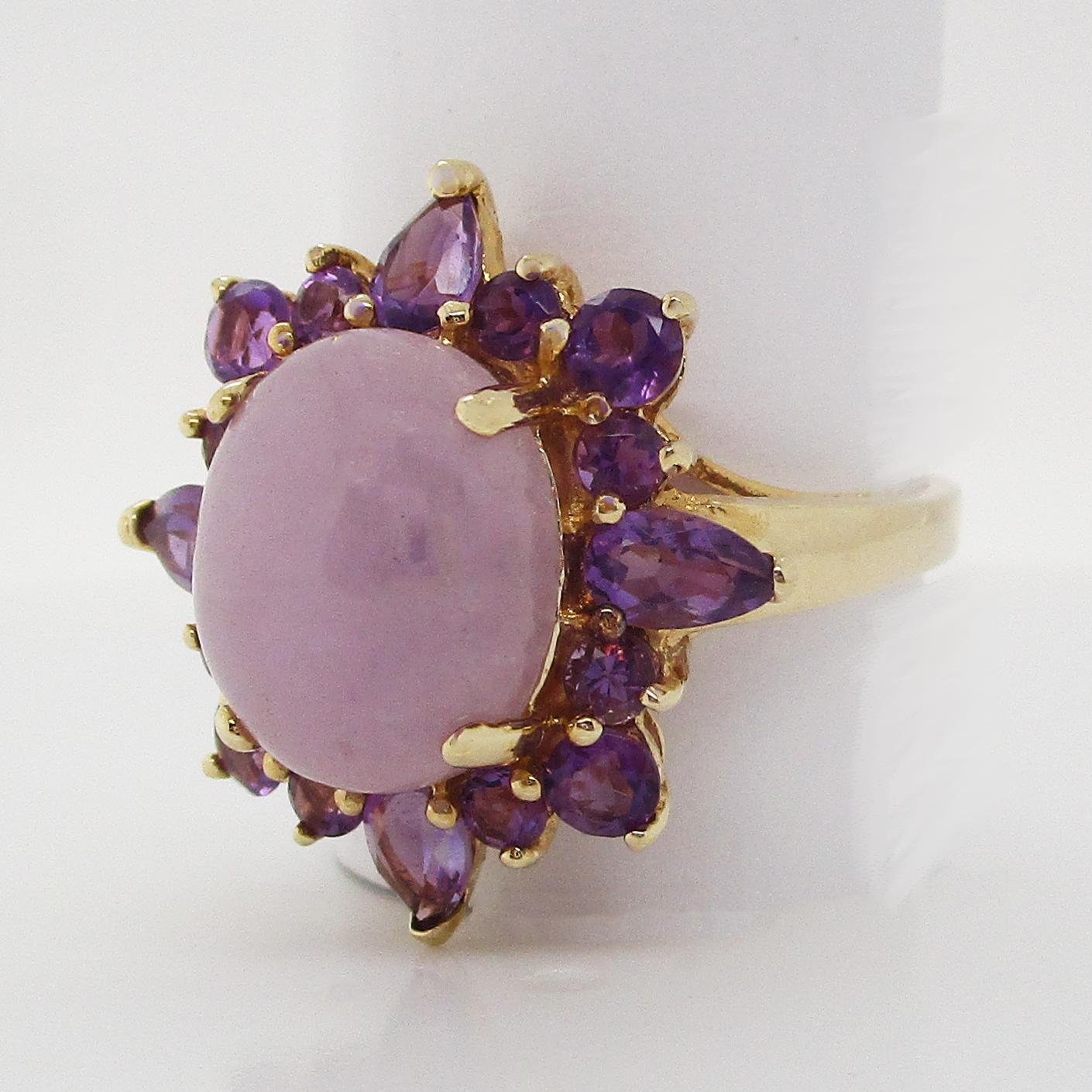 This is a stunning cocktail statement ring in 14k yellow gold featuring a remarkable lavender jade cabochon center framed with a row of amethyst. The ring has an arching undergallery that perfectly supports the lavender jade center and the amethyst!