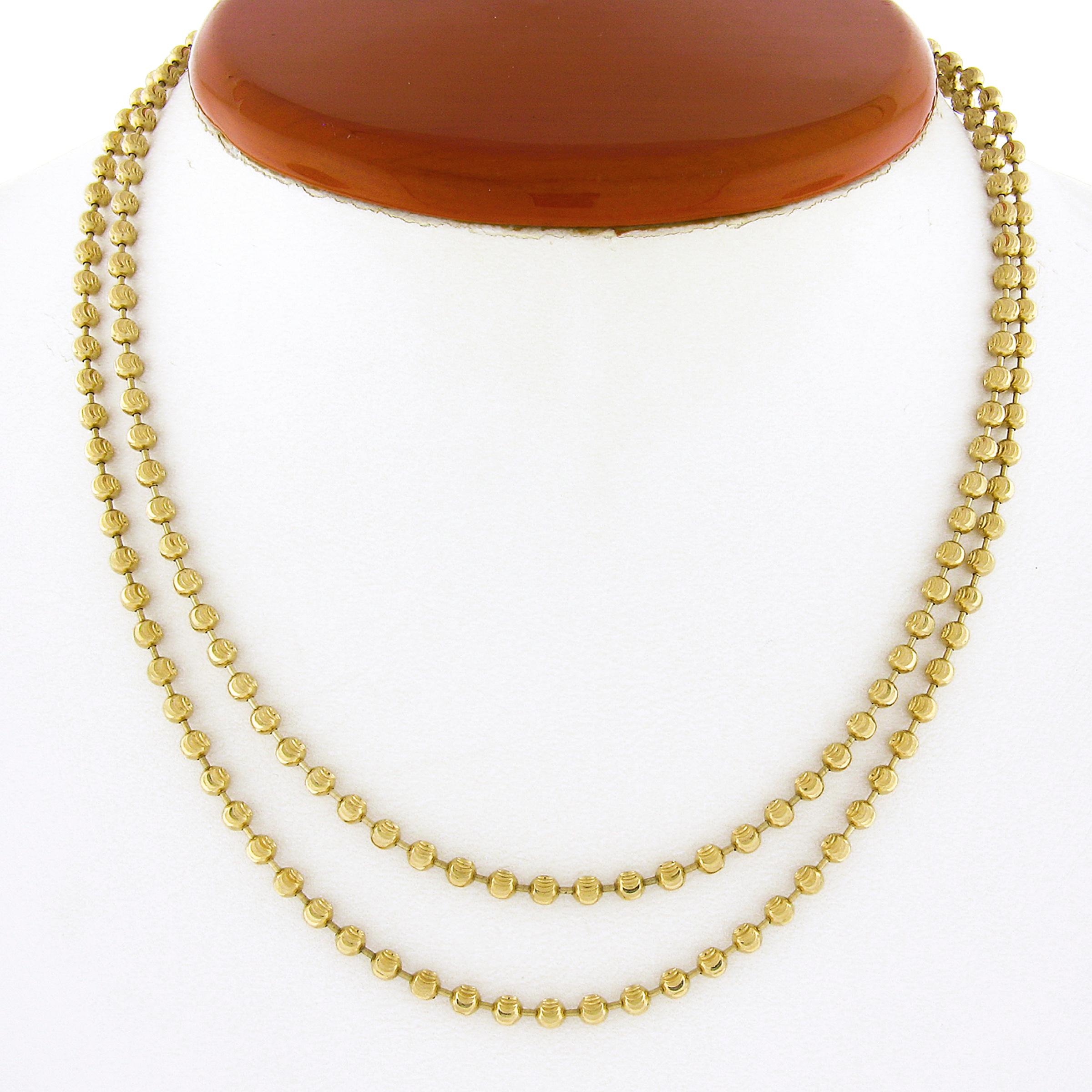 This fine bead/ball link chain necklace is very well crafted in solid 14k yellow gold. The long necklace is 30.5 inches in length, 2.9mm thick, and is secured with a sturdy lobster claw clasp that ensures safe wear. The moon cutting technique on the