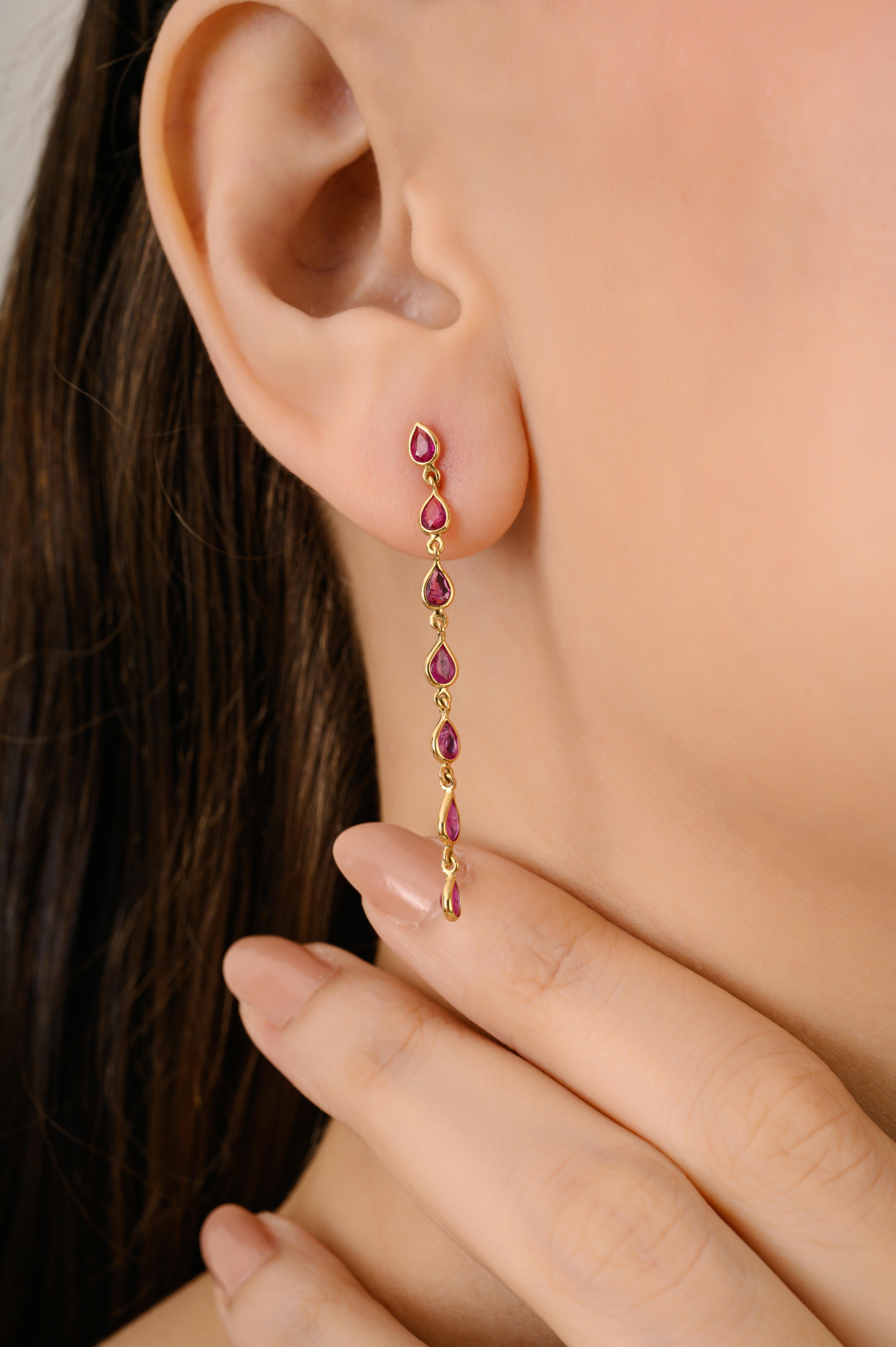 Questi eleganti orecchini a goccia lunghi sono realizzati in oro giallo massiccio 14K e presentano un totale di 2,31 carati di rubini a forma di pera. Ogni rubino è sapientemente incastonato in una linea verticale, permettendo alle pietre di