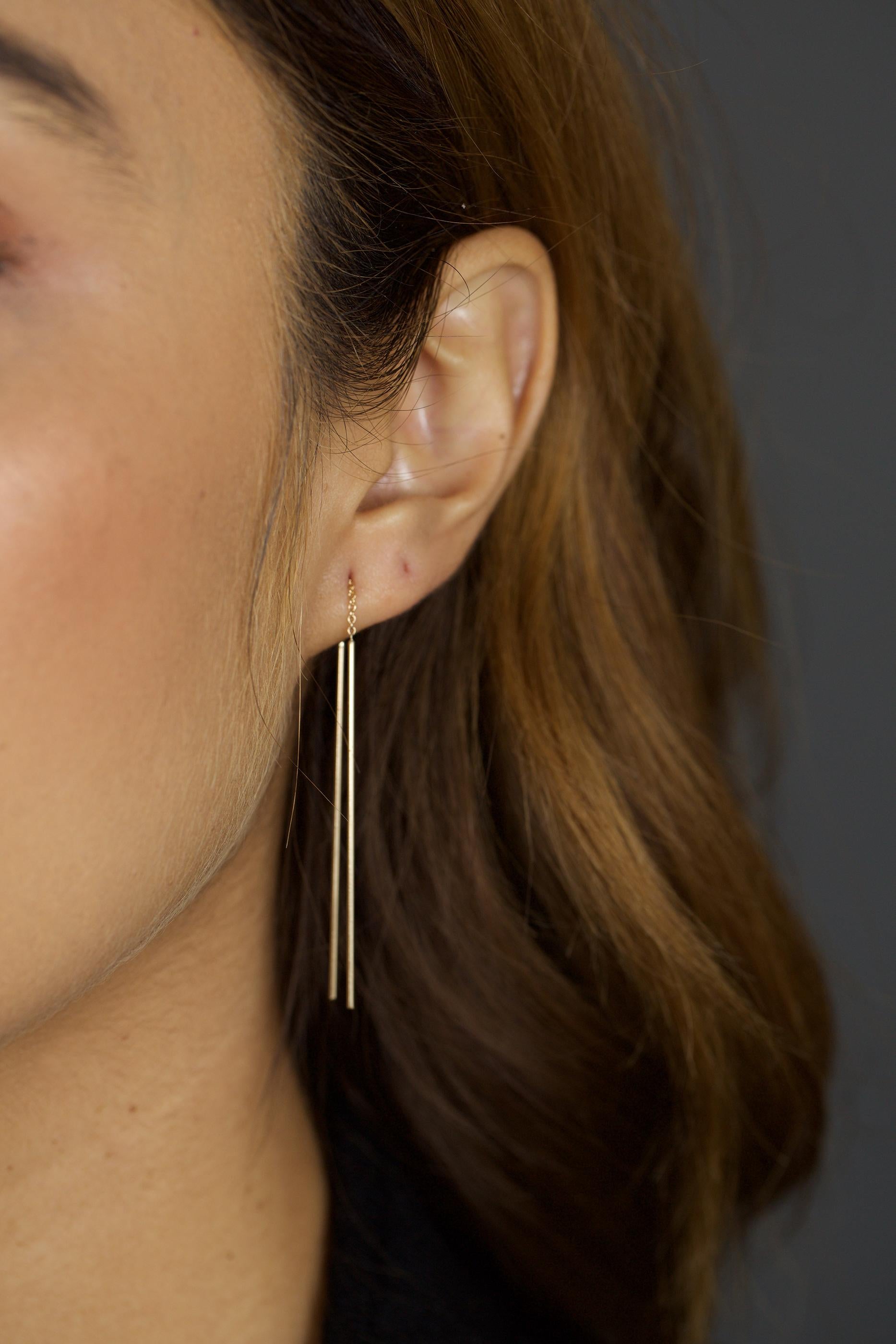Eye-catching with lots of movement these modern gold earrings comfortably thread through the ear with 2 long bars that hang from either side.  Great worn traditionally or double them up on one ear for a little more edge. 
Available in 14kt yellow