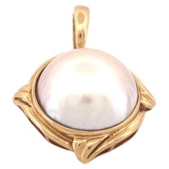 Colgante de oro amarillo de 14 quilates con perla mabe engastado en bisel con gran enganche