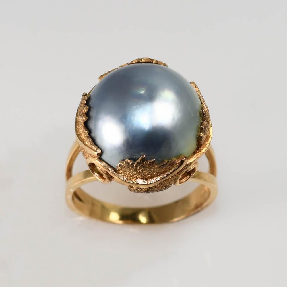 Bague de dame vintage, en perle de mabe dans une monture en or jaune 14k. 
L'or est testé à 56,5 % avec un analyseur de métaux XRF.
Le haut de l'anneau mesure 17 mm de large.
La perle est une grande perle mabe, gris argenté. Design/One attrayant sur