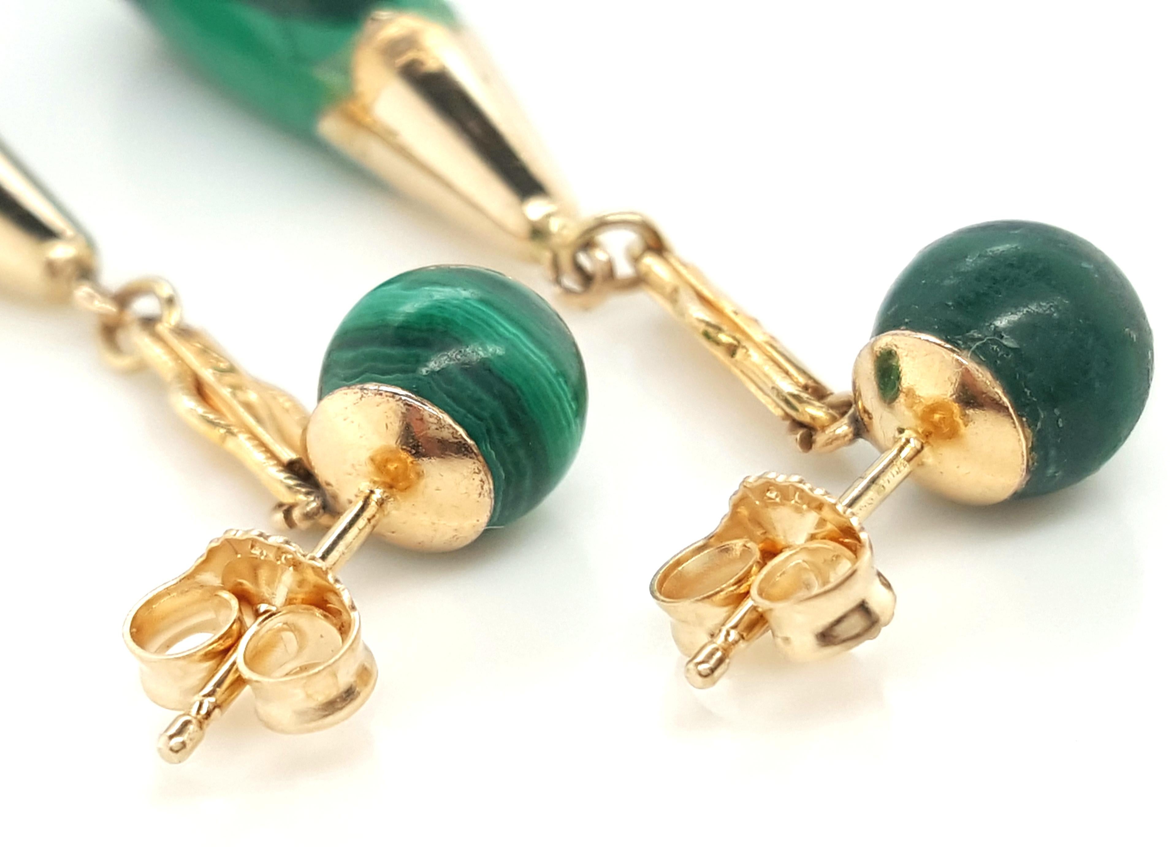 14 Karat Yellow Gold Malachite Drop Earrings, Circa 1980's. The earrings feature a beautiful and striking pair of pear shaped smooth briolette cut malachites each set into a 14 karat yellow gold cap with an undulating detail suspended by a textured