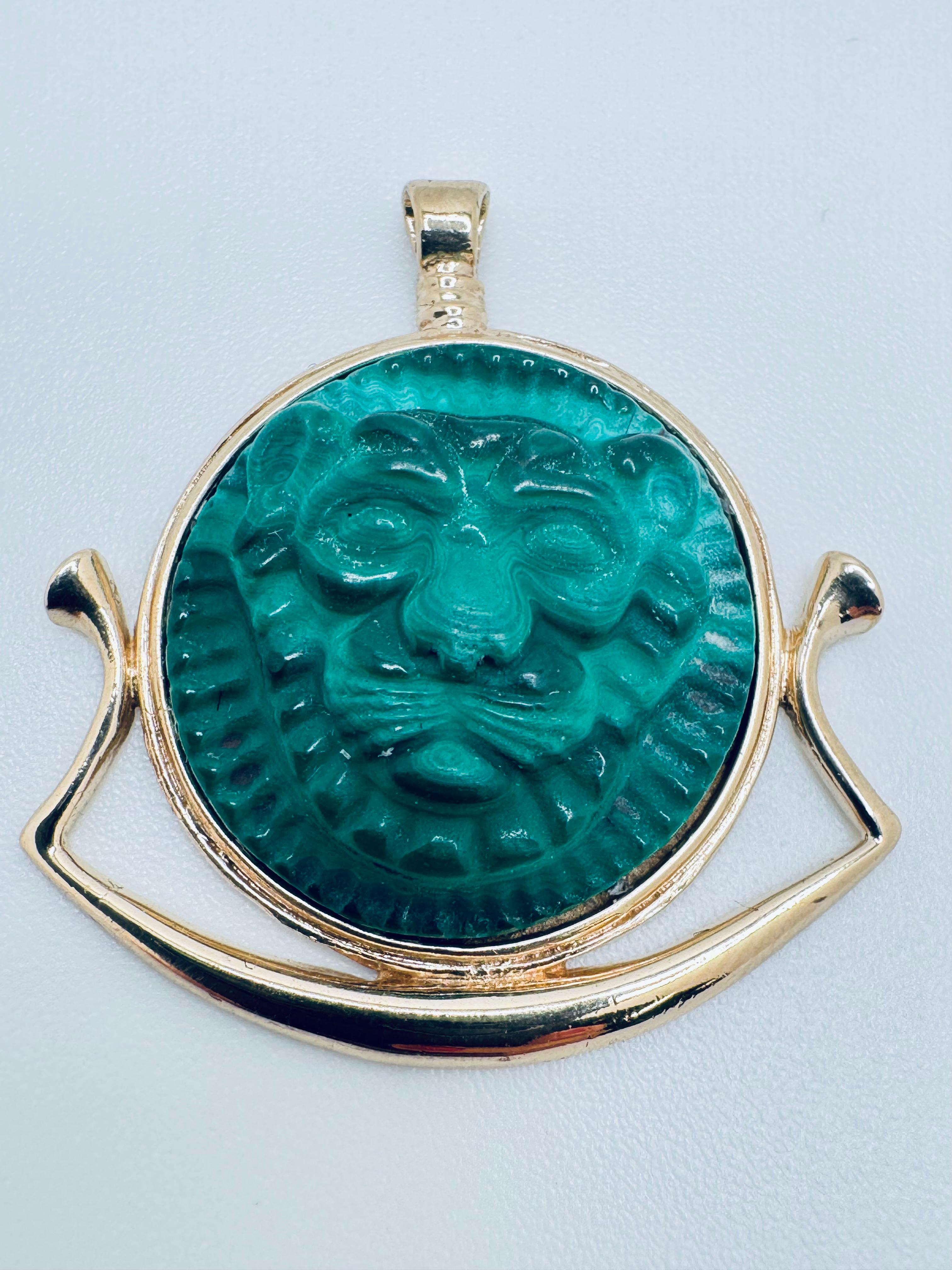 Cette breloque Lion en malachite est un mélange saisissant d'artisanat luxueux et d'art vintage, réalisée en or jaune 14 carats poli. La pièce maîtresse est un lion en malachite sculpté à la main, présentant des détails complexes qui capturent la