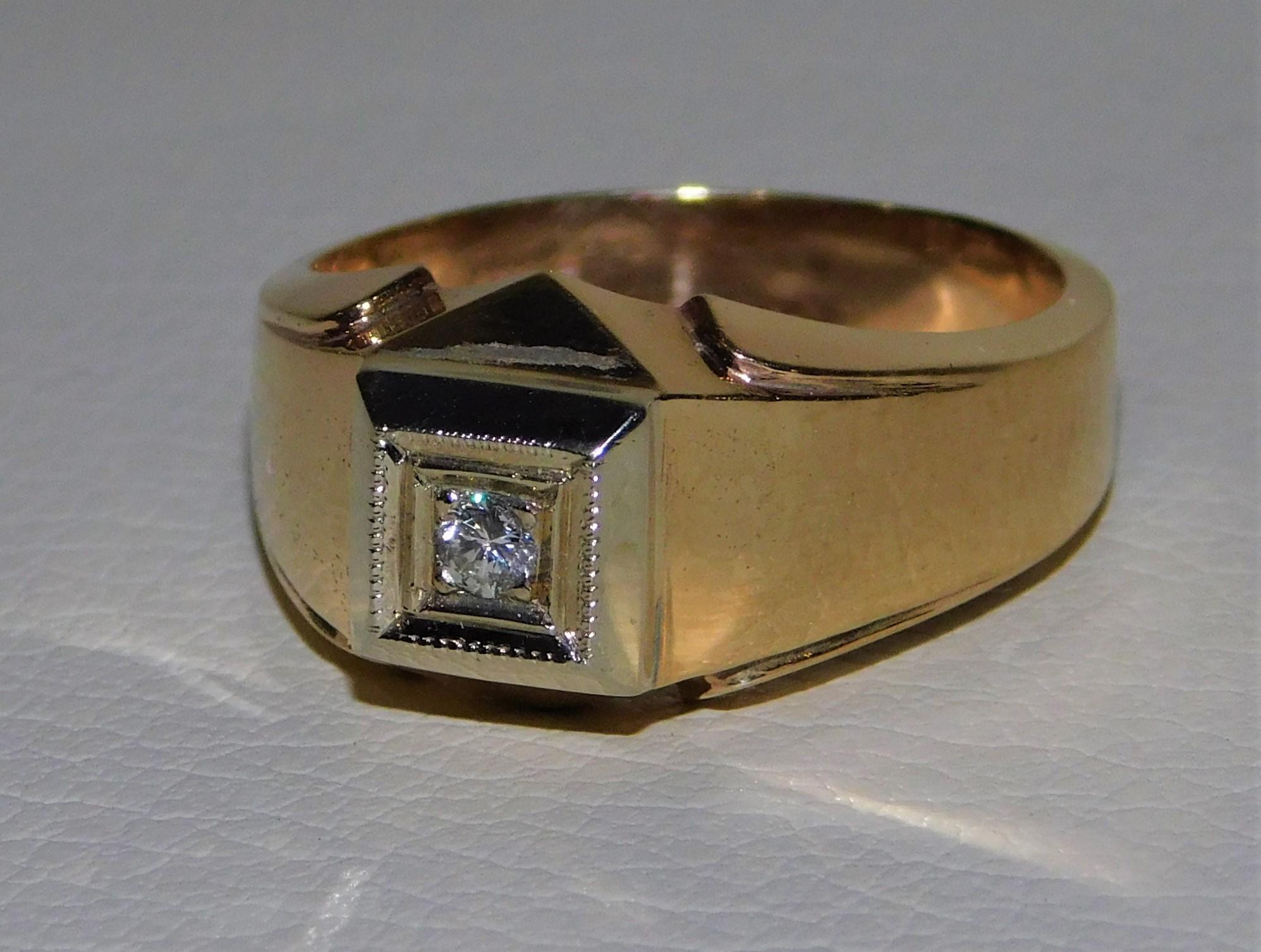 Stamped 14-karat yellow gold man's diamond ring with a bright polish and textured finish. Condition is very good. Square top ring with round brilliant cut diamond surrounded by a milgrain border. Ring measures approximately 11.25 mm at the widest