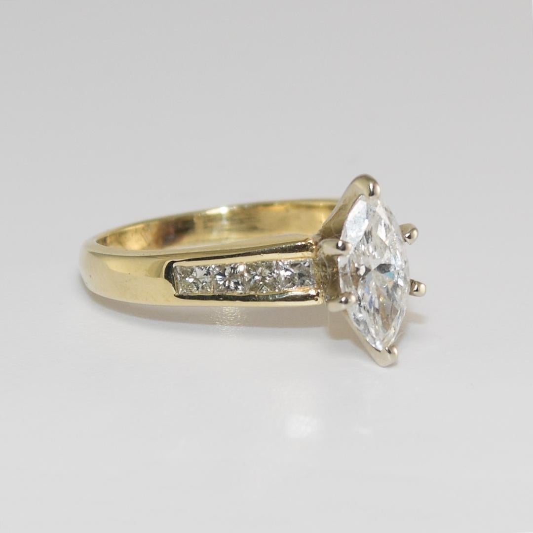 Cette bague en or jaune 14k est ornée d'un diamant central de forme marquise de 0,90ct de pureté i1 et de couleur G - H - I monté sur une monture à 6 branches.
Il y a une petite fracture naturelle sur le bord de la ceinture extérieure au milieu du