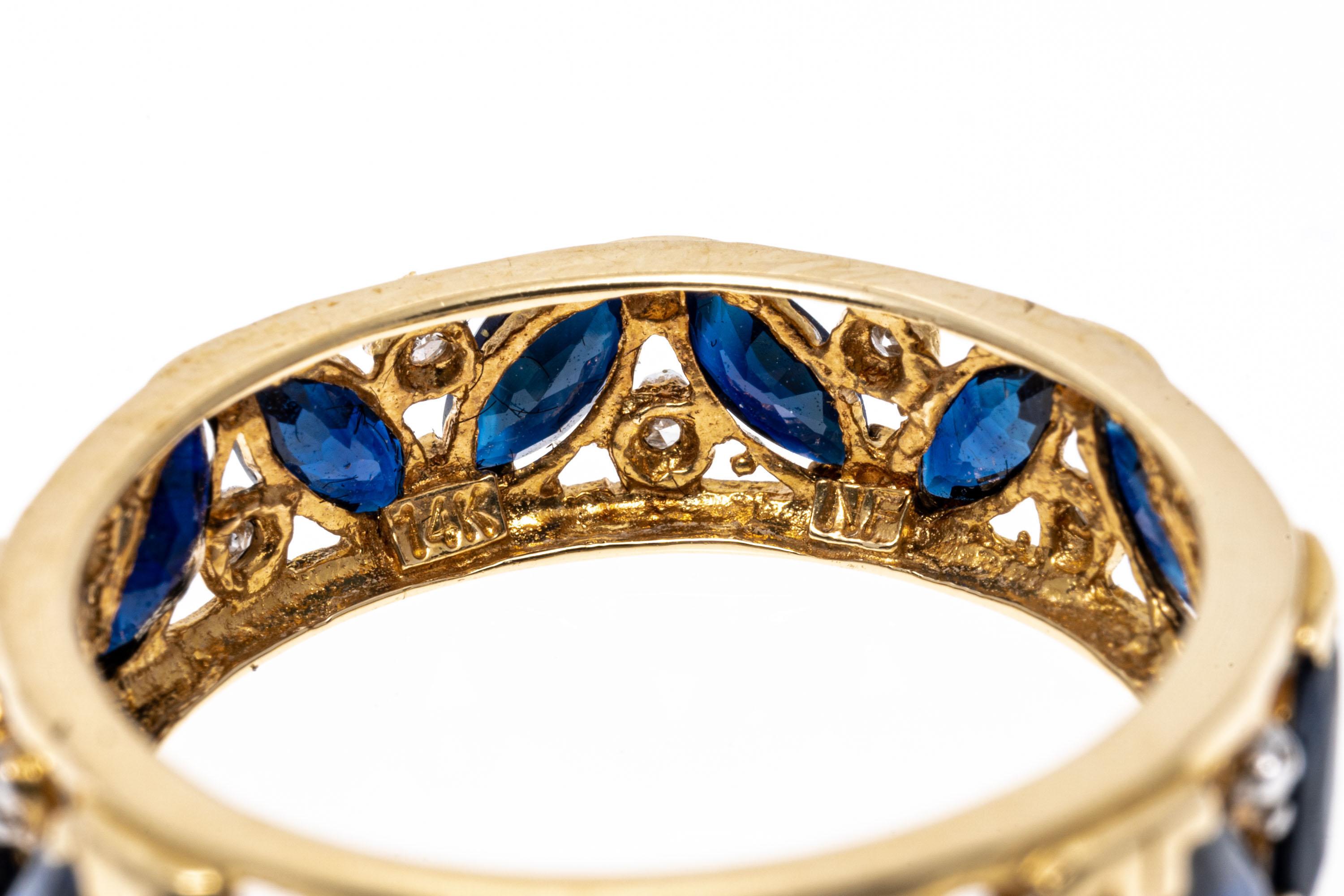 14k yellow gold ring. This striking eternity band ring has tilted marquise faceted, dark blue color sapphires, approximately 1.44 TCW, prong set in an alternating pattern and decorated with round faceted accent diamonds, approximately 0.04