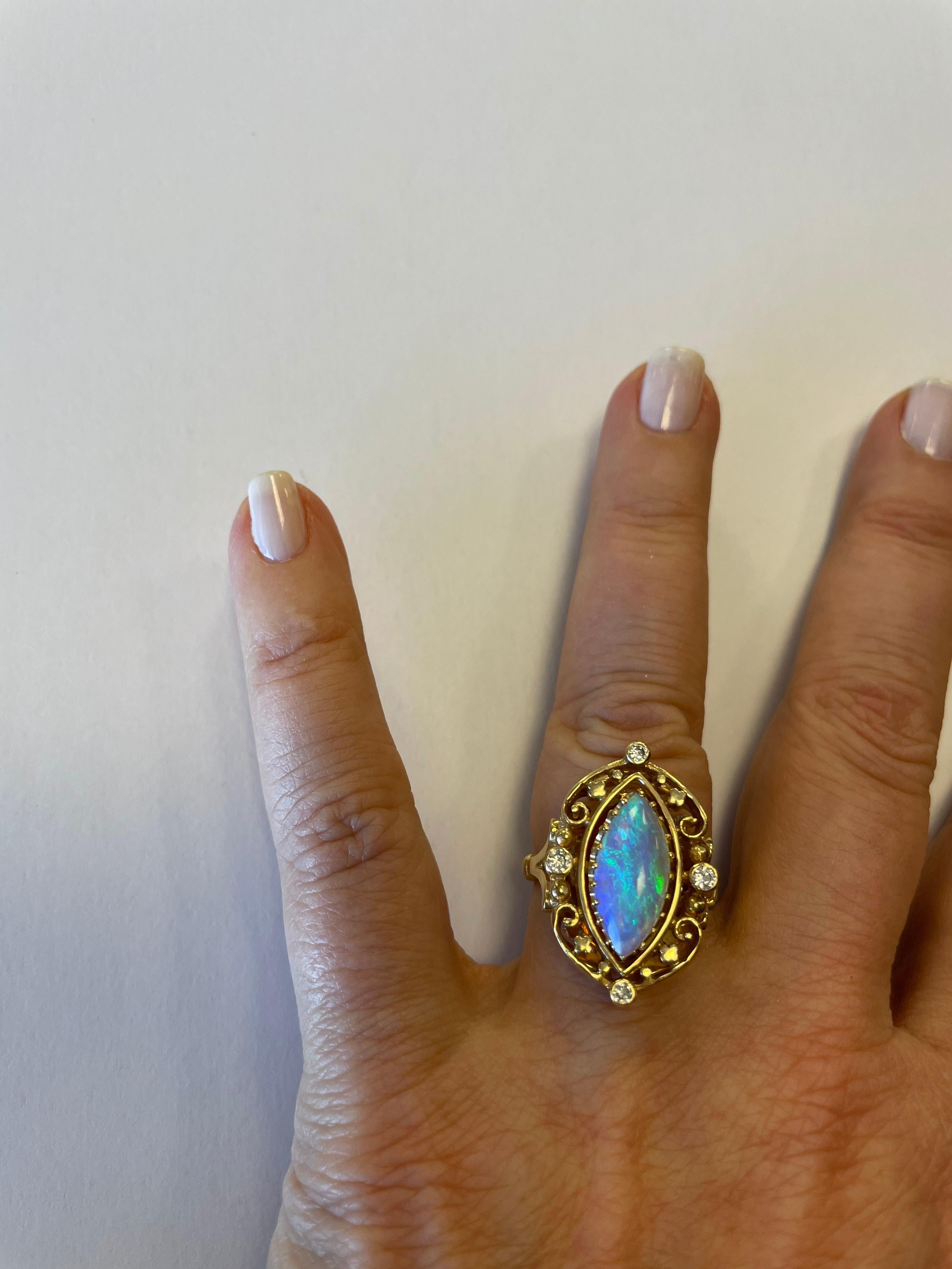 Vintage design, 14K yellow gold ring, prong set with Marquise shaped Opal measuring  16mm x 8mm and 4 full cut round diamonds weighing .20cts total
finger size 5, may be resized