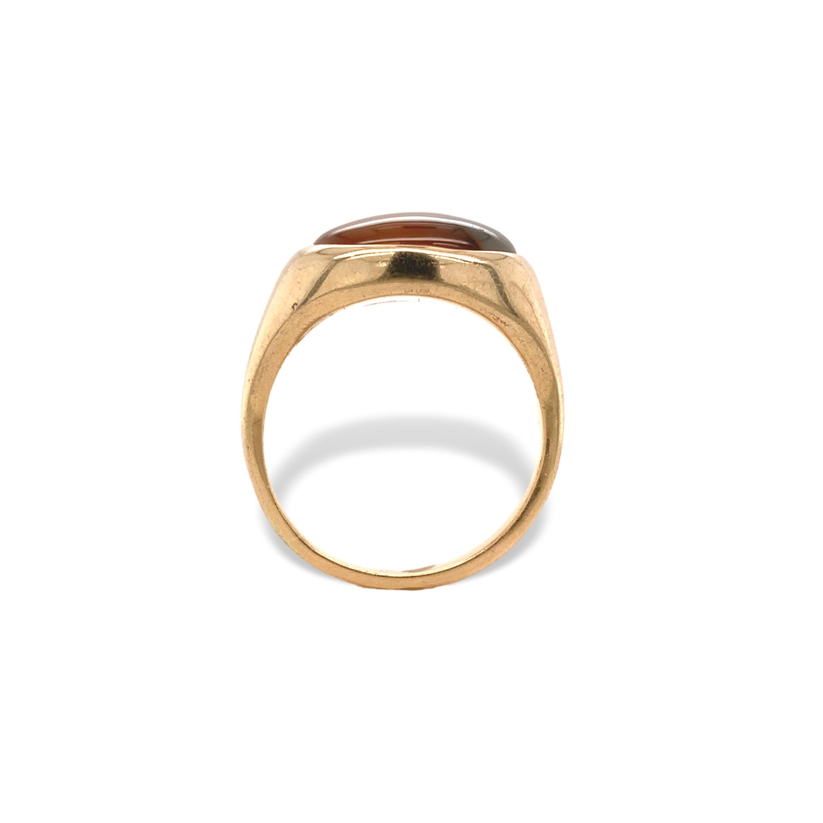 14K yellow gold men's hand made ring featuring an oval cabochon agate. The agate has golden orangey-yellow color with some black banding. It measures about 13mm x 9mm. The ring is solid and the stone is flush set directly into the gold. The ring