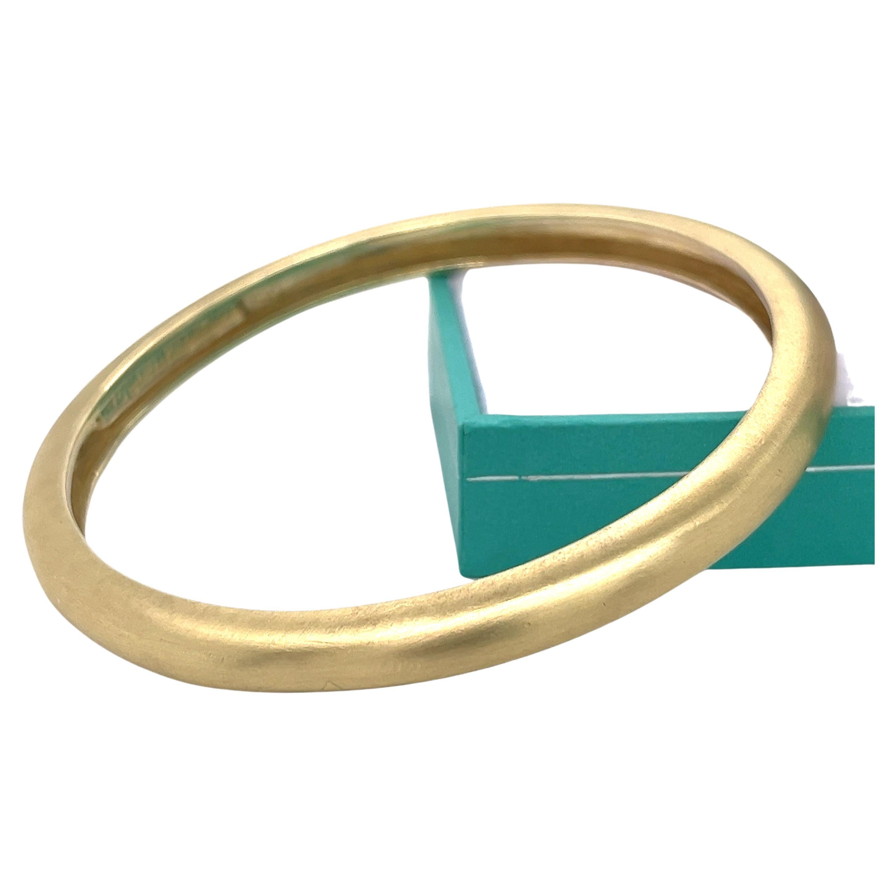 This 14 karat yellow gold bangle bracelet from Mignon Faget is a beautiful piece of jewelry. With a width of 6.35mm and a diameter of 2.5 inches, it has a brushed gold finish that adds texture and character to the design. Weighing in at 48 grams,