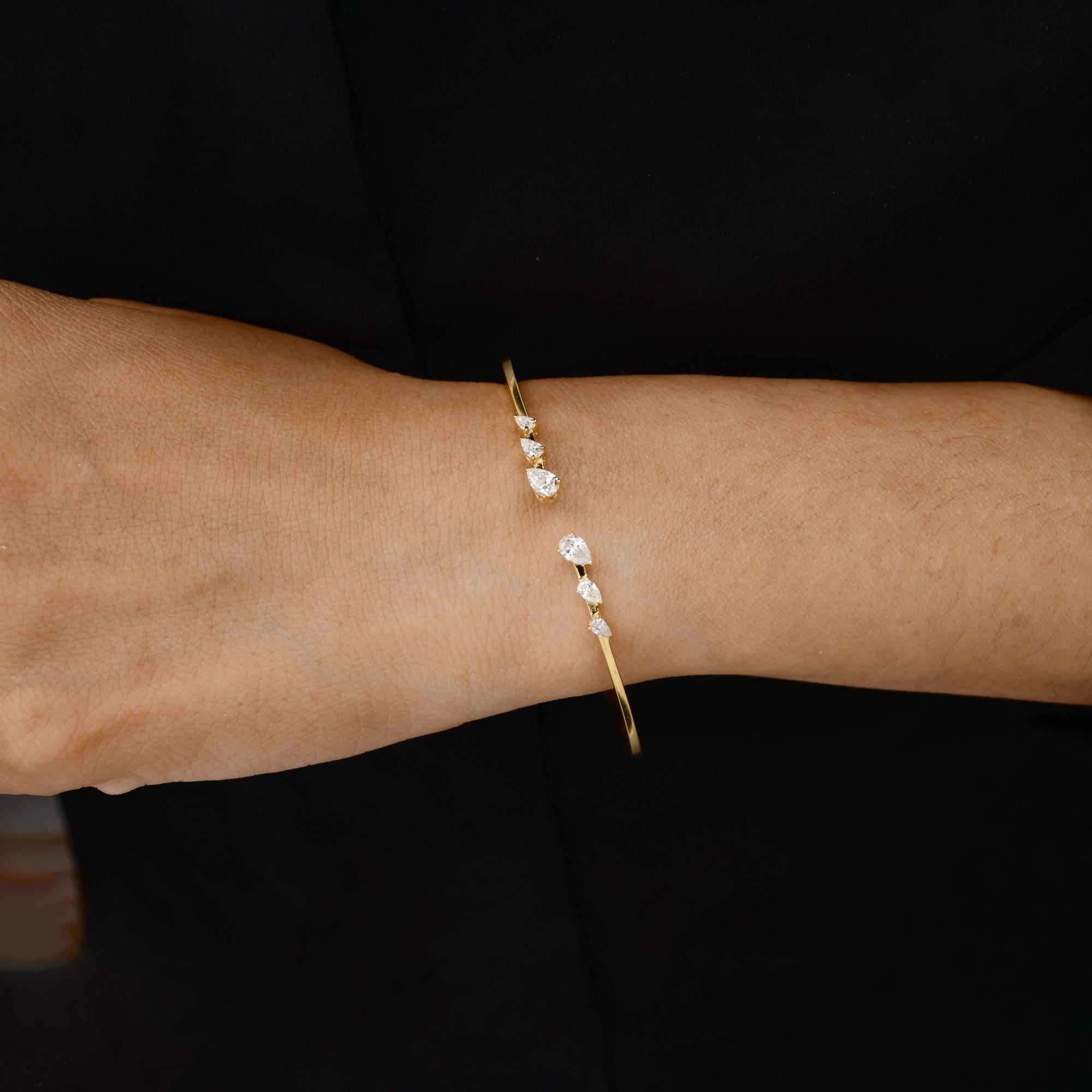 Pulsera brazalete de oro amarillo de 14 quilates con diamantes SI/H en graduación mínima para mujer
La pulsera luce una elegante banda dorada. El diseño central presenta seis diamantes en forma de pera dispuestos con gracia a lo largo del arco
