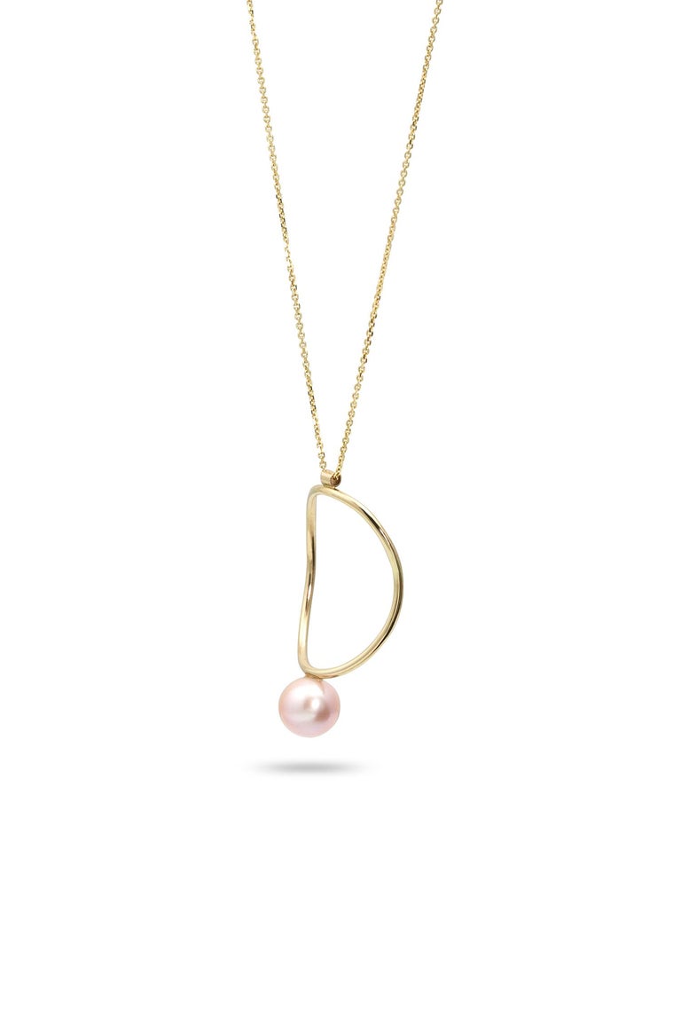 Strikingly minimal in its design, this 14k yellow gold necklace is as beautiful on bare skin as it is layered over a tee or lightweight turtleneck. The gentle curves of its hand-formed circle and single pink pearl remind us of our favorite