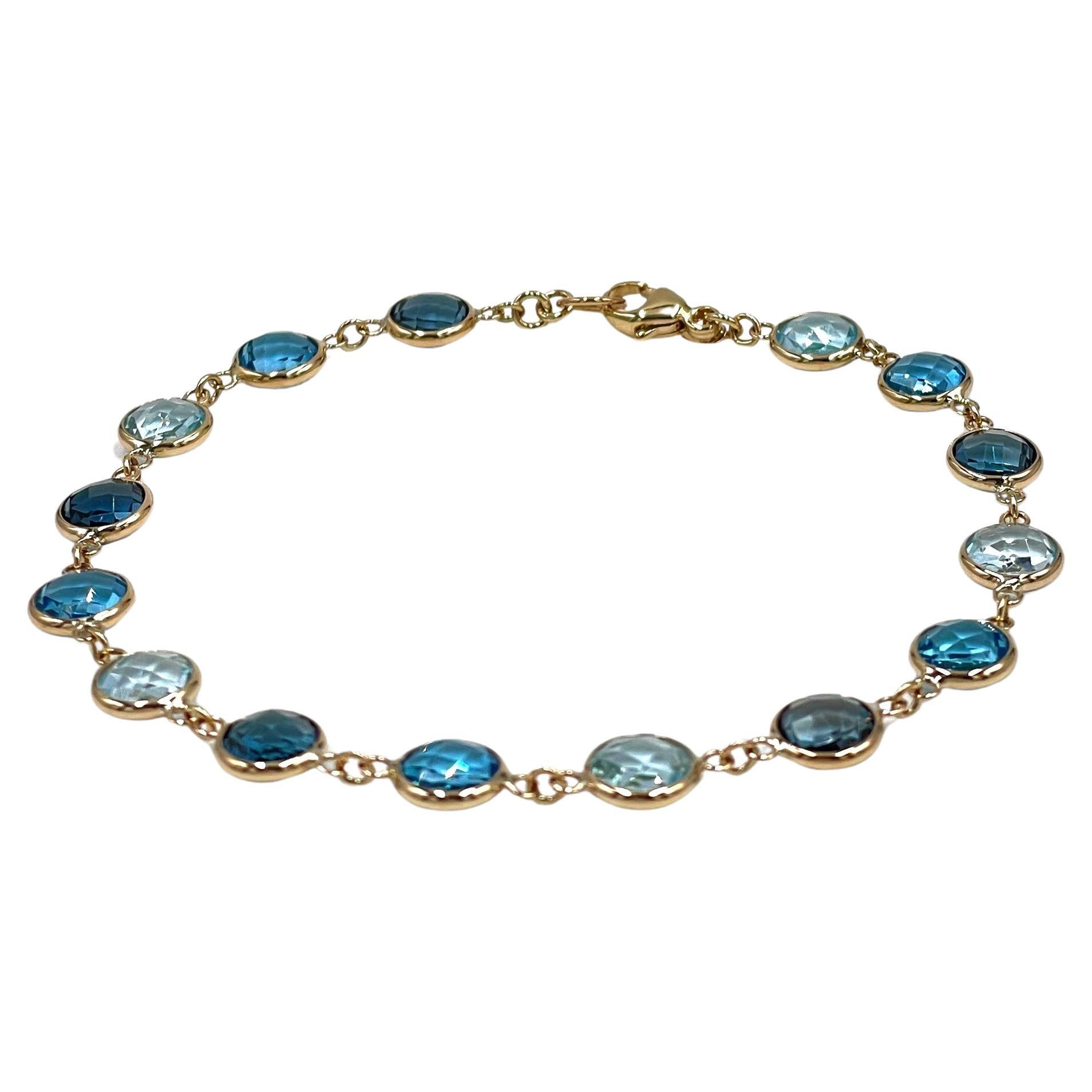 14K yellow gold multi-color blue topaz bracelet. The bracelet features three different shades of blue topaz, sky blue, Swiss blue and London blue.  The topazes are bezel set in 14K yellow gold and are linked together creating the perfect everyday