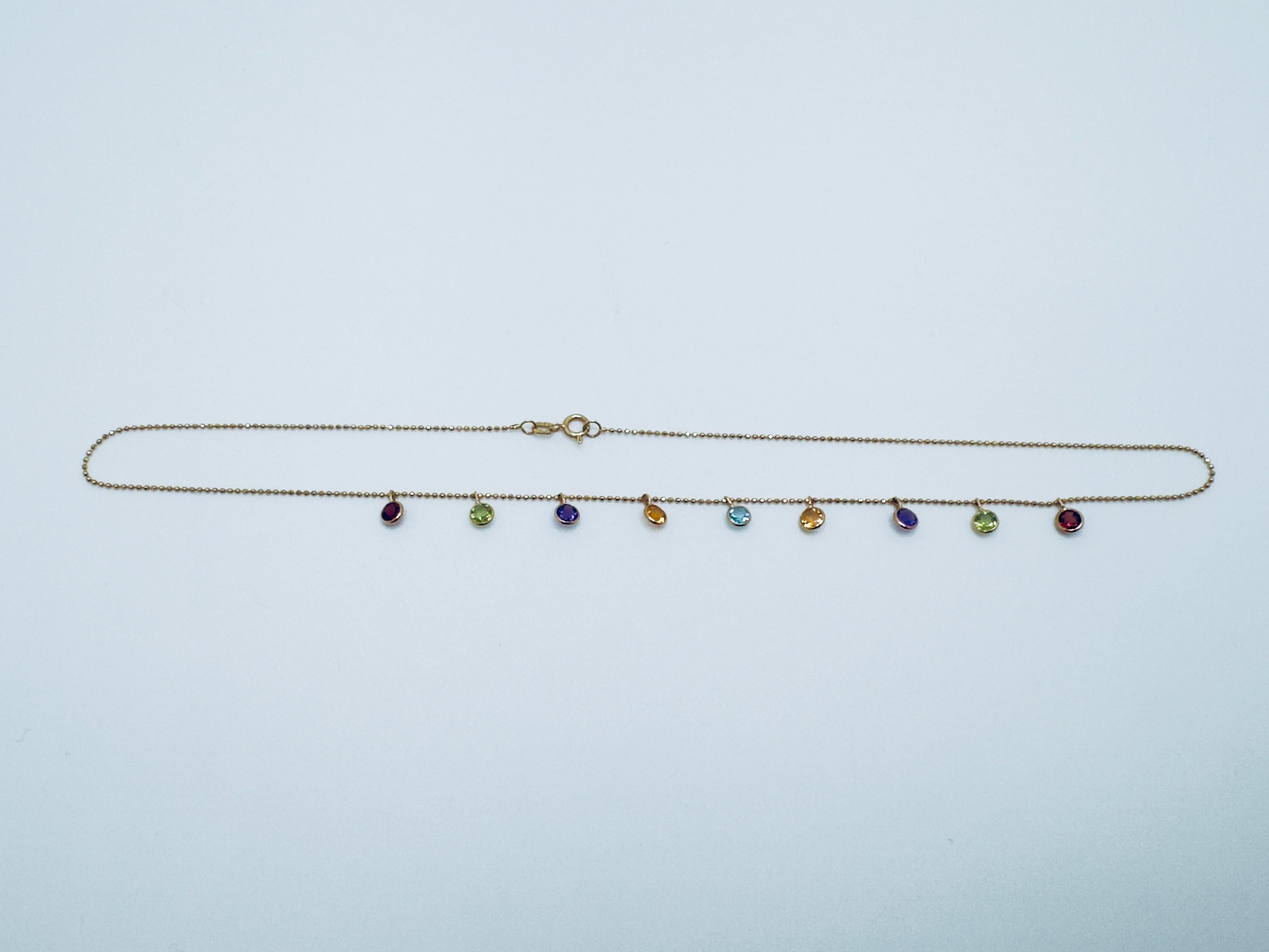 This vibrant 14K yellow gold dangle necklace showcases a delightful array of multi-colored gemstones, creating a playful yet elegant accessory. The necklace features a 16-inch chain, weighing 2.7 grams, designed for comfortable everyday wear or