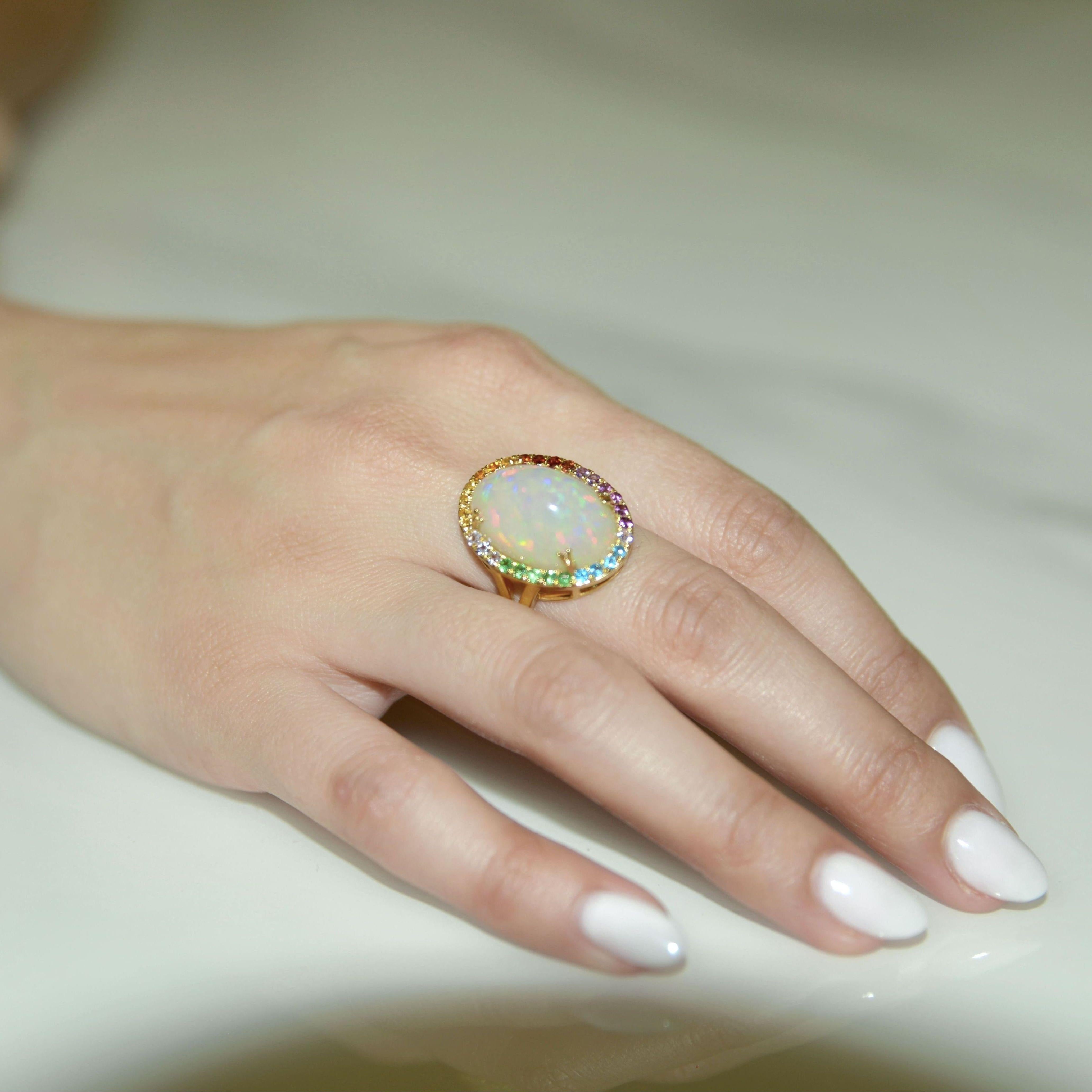 This 14K Yellow Gold Opal Ring the epitome of elegant jewelry. Opal jewelry is often admired by its flash of color and this opal ring does not disappoint with its play of color. Decorated with the different gemstones representing the different