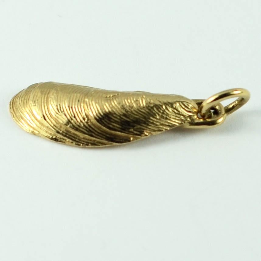A 14 karat (14K) yellow gold charm pendant designed as a mussel shell. Stamped 14K for 14 karat gold and American manufacture with an unknown makers mark.

Dimensions: 2.6 x 0.8 x 0.4 cm
Weight: 2.10 grams
