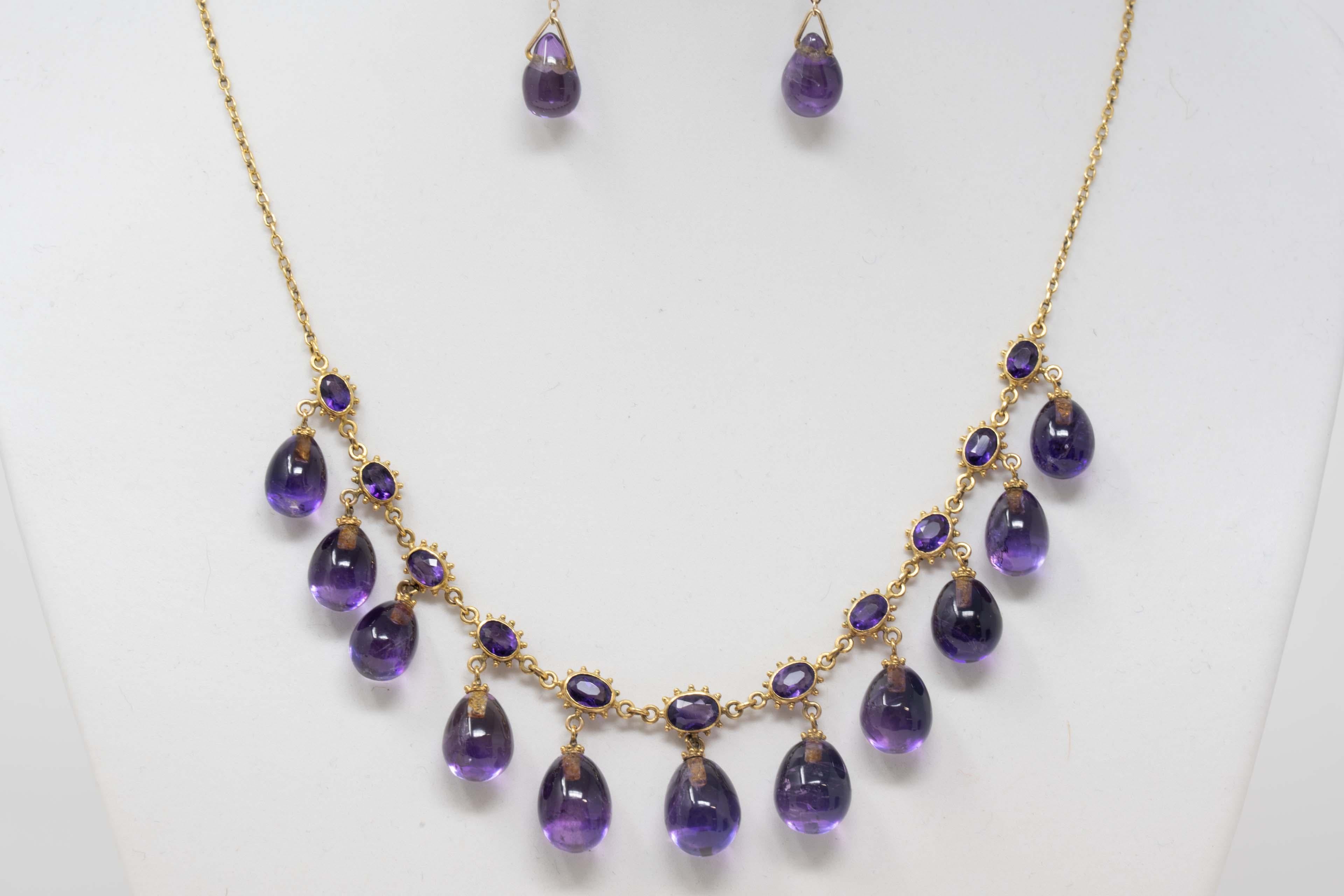 Vintage 14k yellow gold & natural amethyst stone necklace and earrings. The necklace includes 11 oval shaped amethysts measuring 5 x 3.5mm and 11 drop shaped amethysts measuring 15mm long x 10mm in diameter. Not stamped but acid tested. The earring