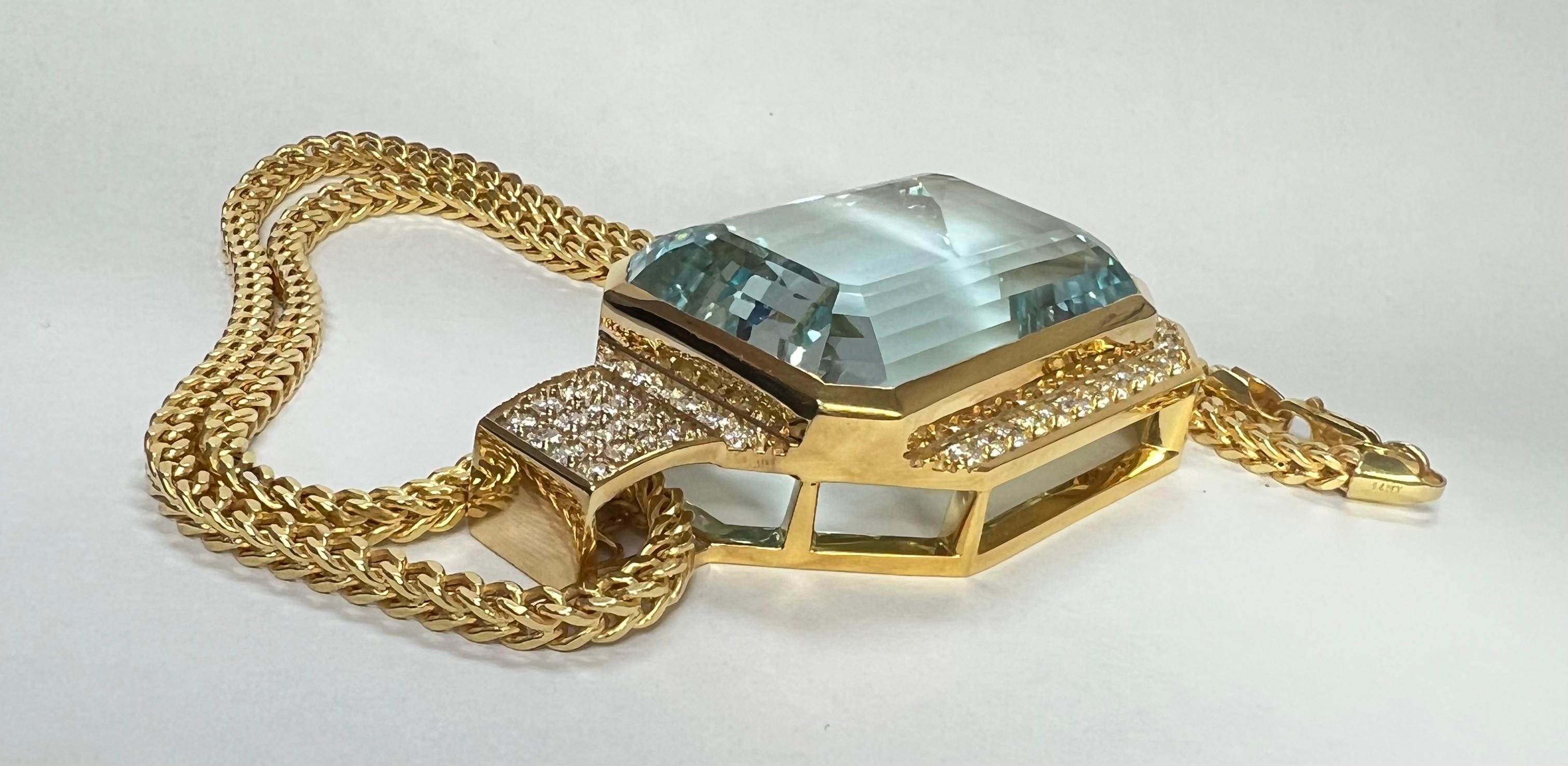 Showcasing a stunning and vibrant Auqamarine Necklace. The pendant offers a perfectly set center Emerald Cut Auqamarine, surrounded by two rows of round brilliant cut Round Diamonds suspended from a beautiful 22 inch chain, all in Yellow Gold. The