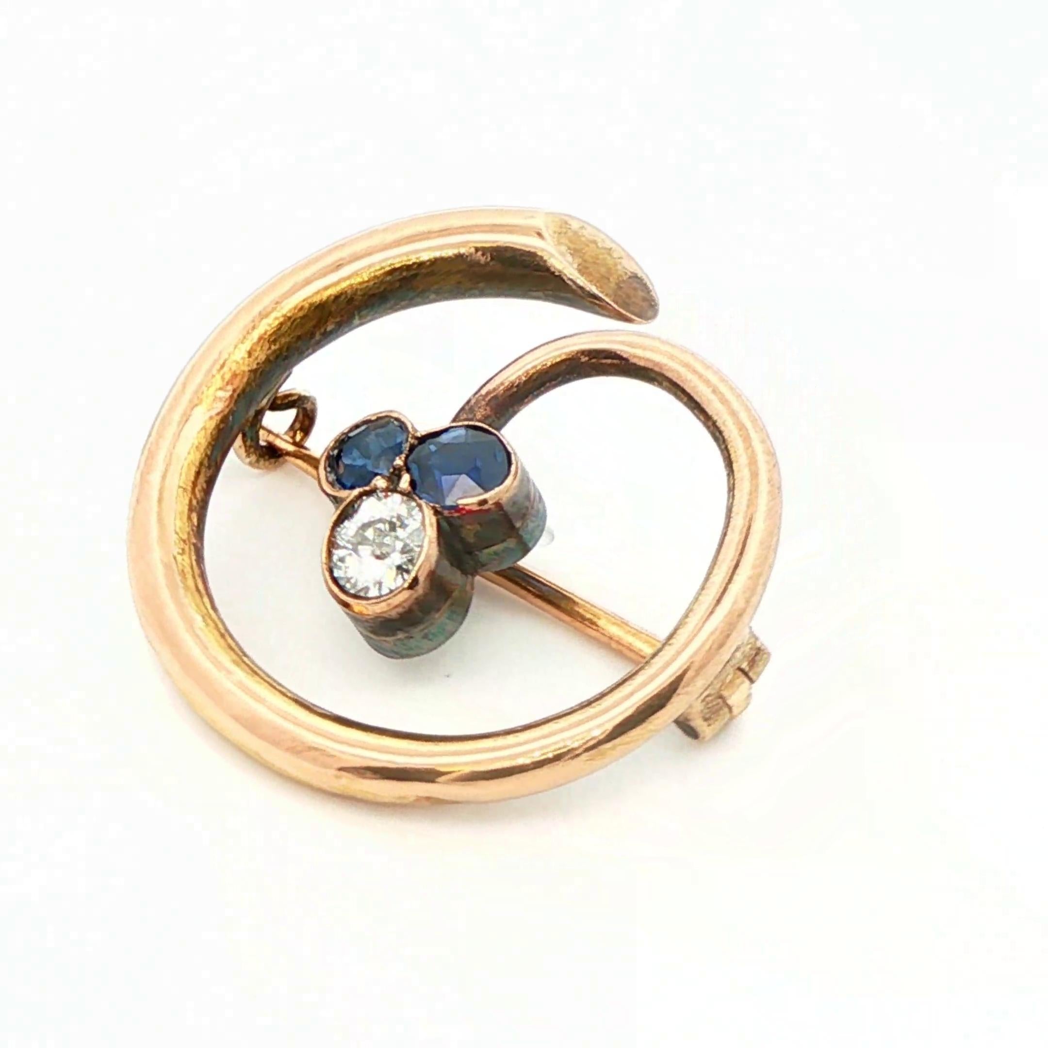 Questa splendida spilla Imperial Gold risale al 1890 ed è stata realizzata in oro giallo 14k con zaffiri naturali e diamanti. Il centro presenta una combinazione di gemme con due zaffiri naturali, senza calore e con taglio misto, che insieme
