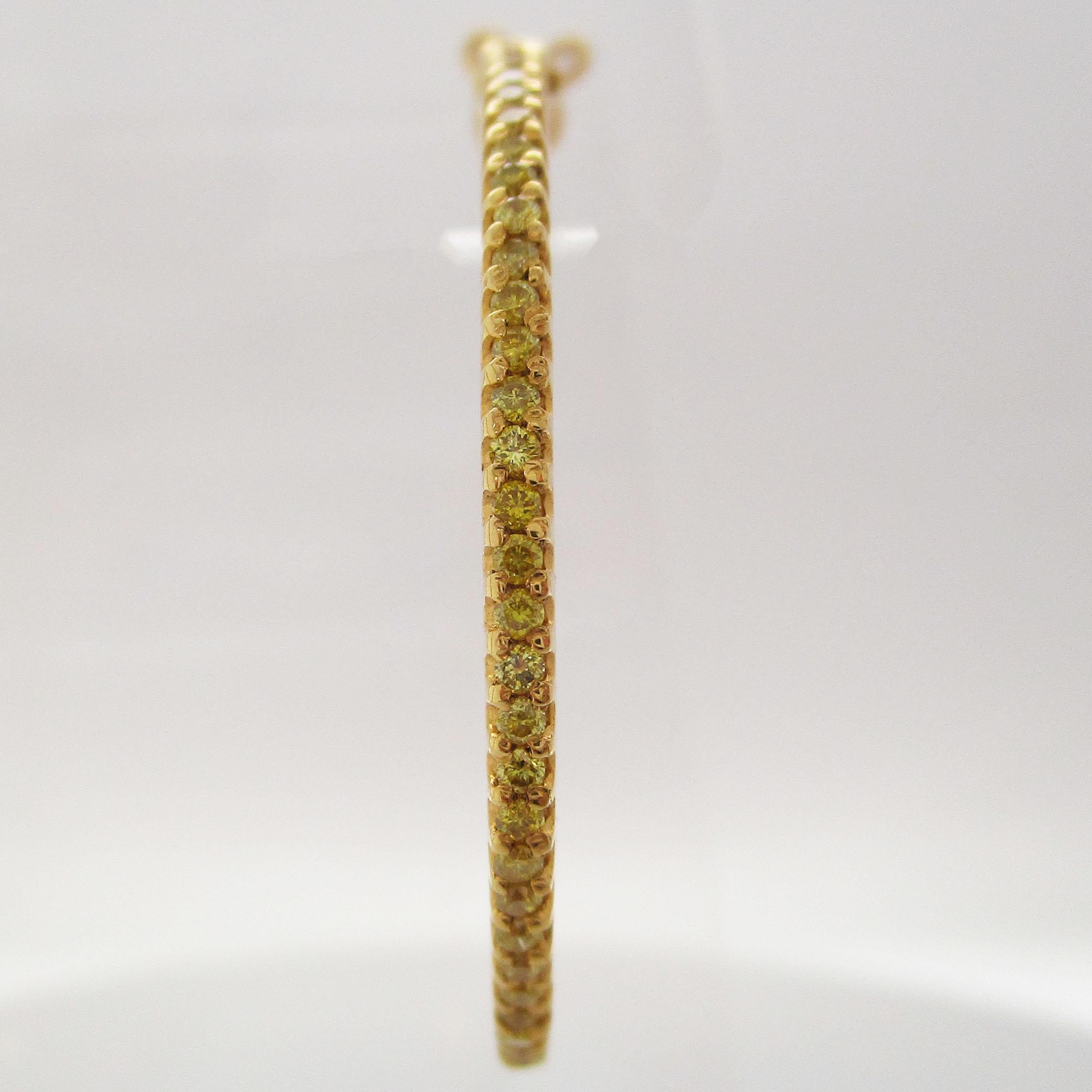 This is a gorgeous pair of hoop earrings in 14k yellow gold studded with beautiful natural fancy yellow diamonds! These earrings take the classic, go-with-everything look of hoop earrings and throw in the enchanting beauty of fancy yellow diamonds