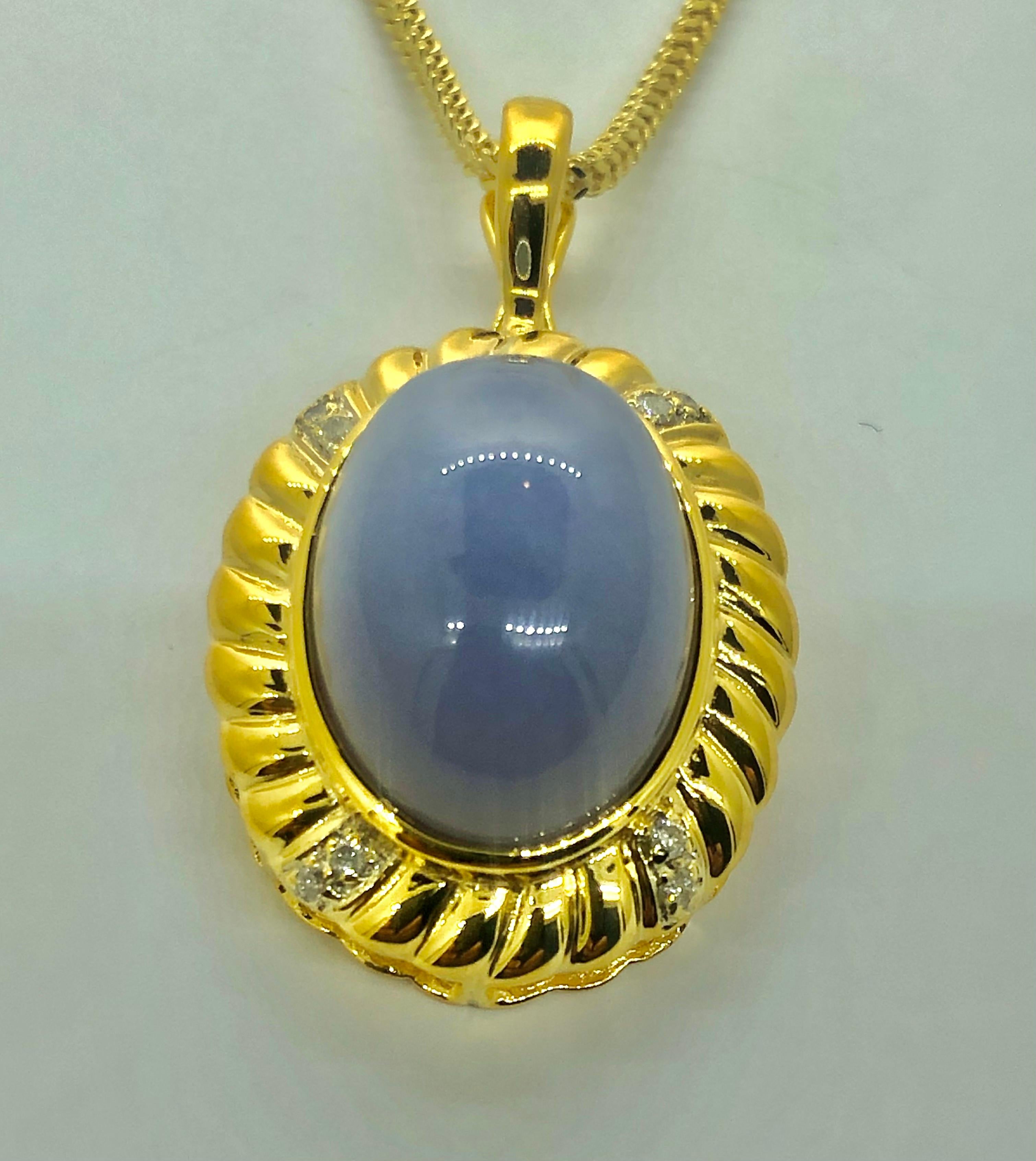 Showcasing a stunning and vibrant Lavender Jade Necklace. The pendant offers a perfectly set center Oval Shape Lavender Jade, surrounded by four rows of brilliant cut Round Diamonds suspended from a beautiful 22 inch chain, all in Yellow Gold. The