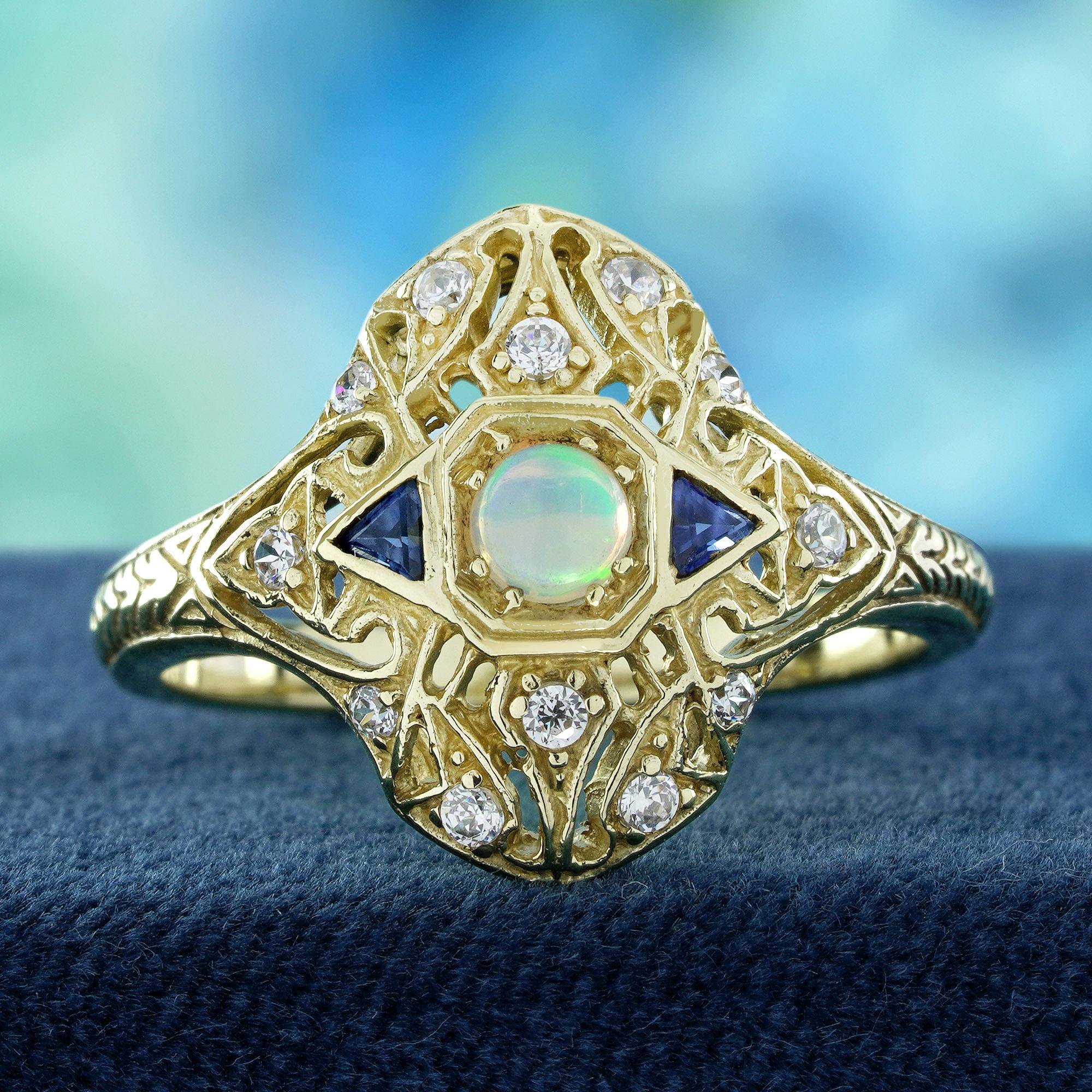 Un luminoso opale naturale rotondo al centro, che brilla di colori iridescenti. Su ogni lato, zaffiri blu triangolari aggiungono un contrasto audace e un'elegante simmetria. La fascia è impreziosita da intricati dettagli intagliati, accentati da
