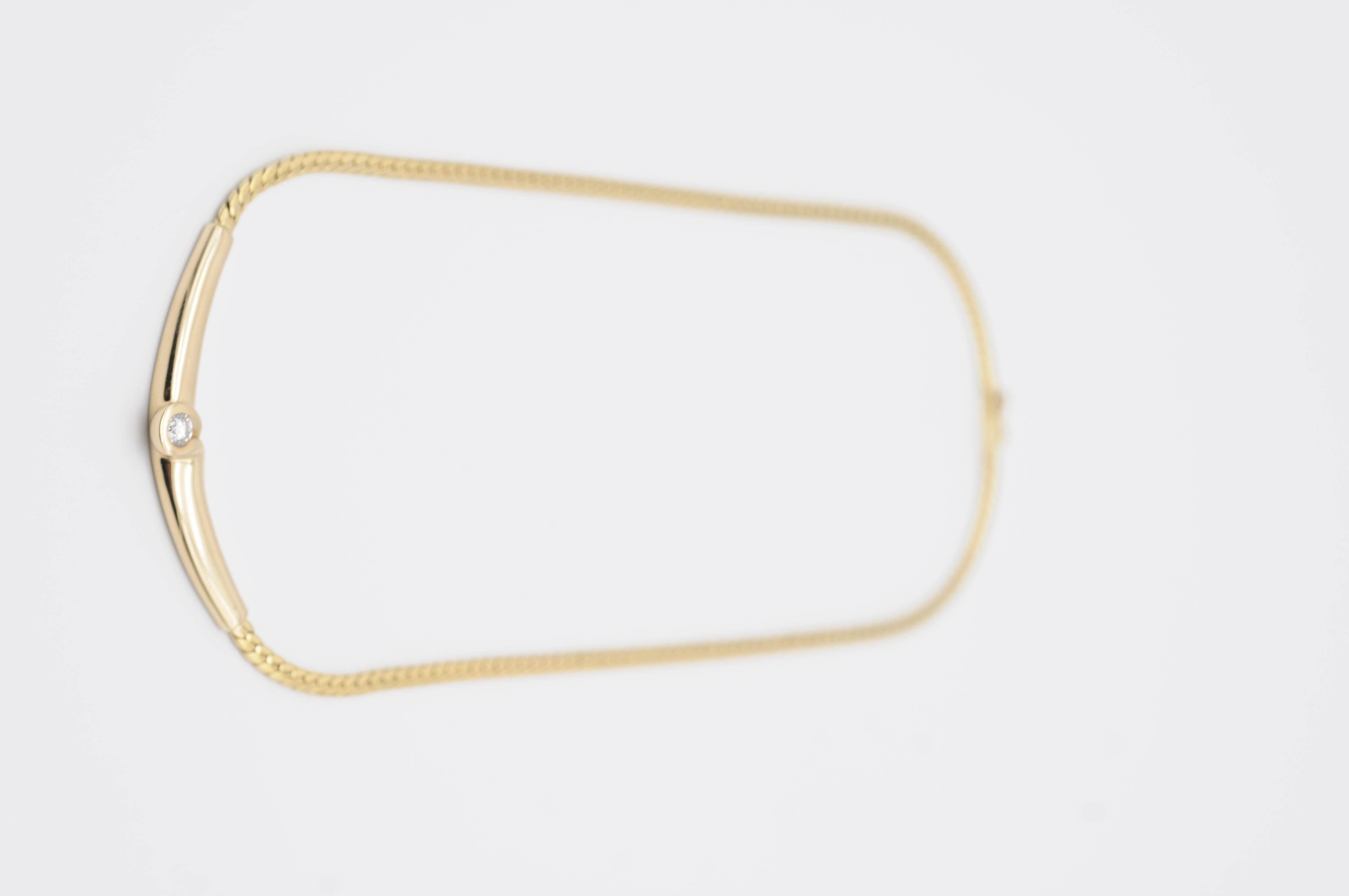This 14K yellow gold necklace/collier is a true masterpiece. The classic link chain is adorned with a stunning red cabochon stone as the centerpiece, surrounded by a halo of sparkling diamonds. The red stone, with its smooth surface and rich hue,
