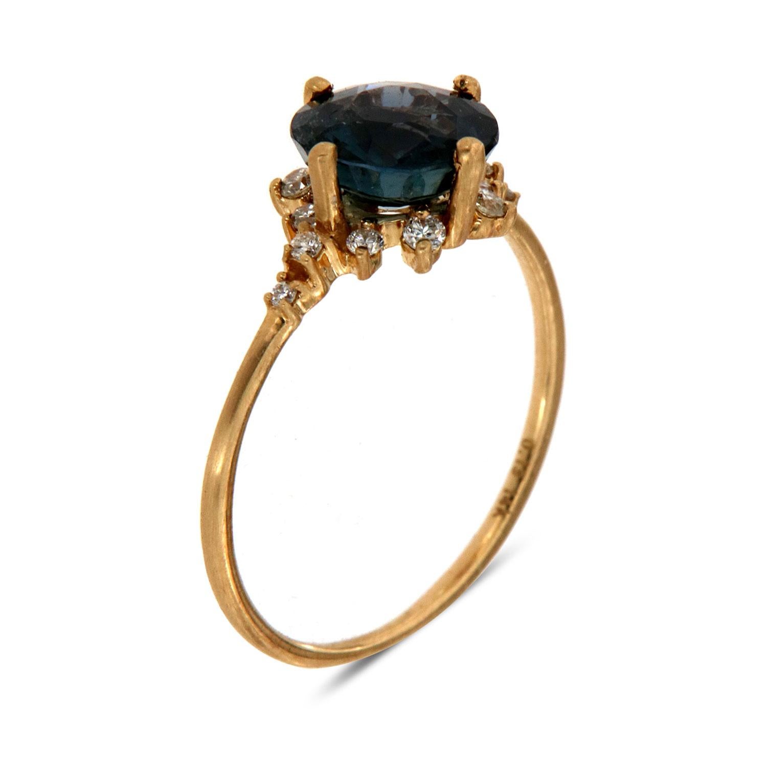 This petite organic style rustic ring is impressive in its vintage appeal, featuring a 1.90 Carat old cut natural unheated Teal color Round shape Sri-Lankan sapphire, accented with a halo of twelve scattered round brilliant diamonds in weight of