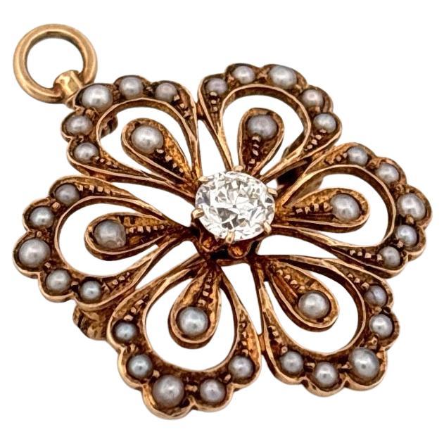 Questo raffinato ciondolo/spilla d'epoca è finemente realizzato in oro giallo 14 carati e presenta un'armoniosa miscela di eleganza senza tempo e di intricata maestria. Disegnato con un delicato motivo floreale, il pezzo presenta al centro un