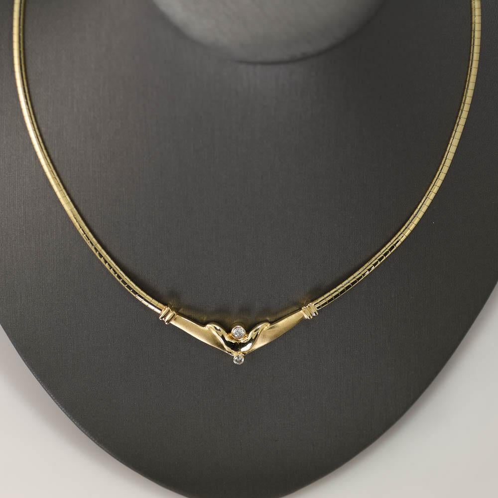 Collier oméga en or jaune 14k avec des diamants.
Estampillé 14k Italie et pèse 22 grammes.
Deux diamants ronds de taille brillant sont sertis dans le pendentif, .20 carats au total, couleur I à J, pureté Si.
Le collier mesure 18 pouces de long et 3