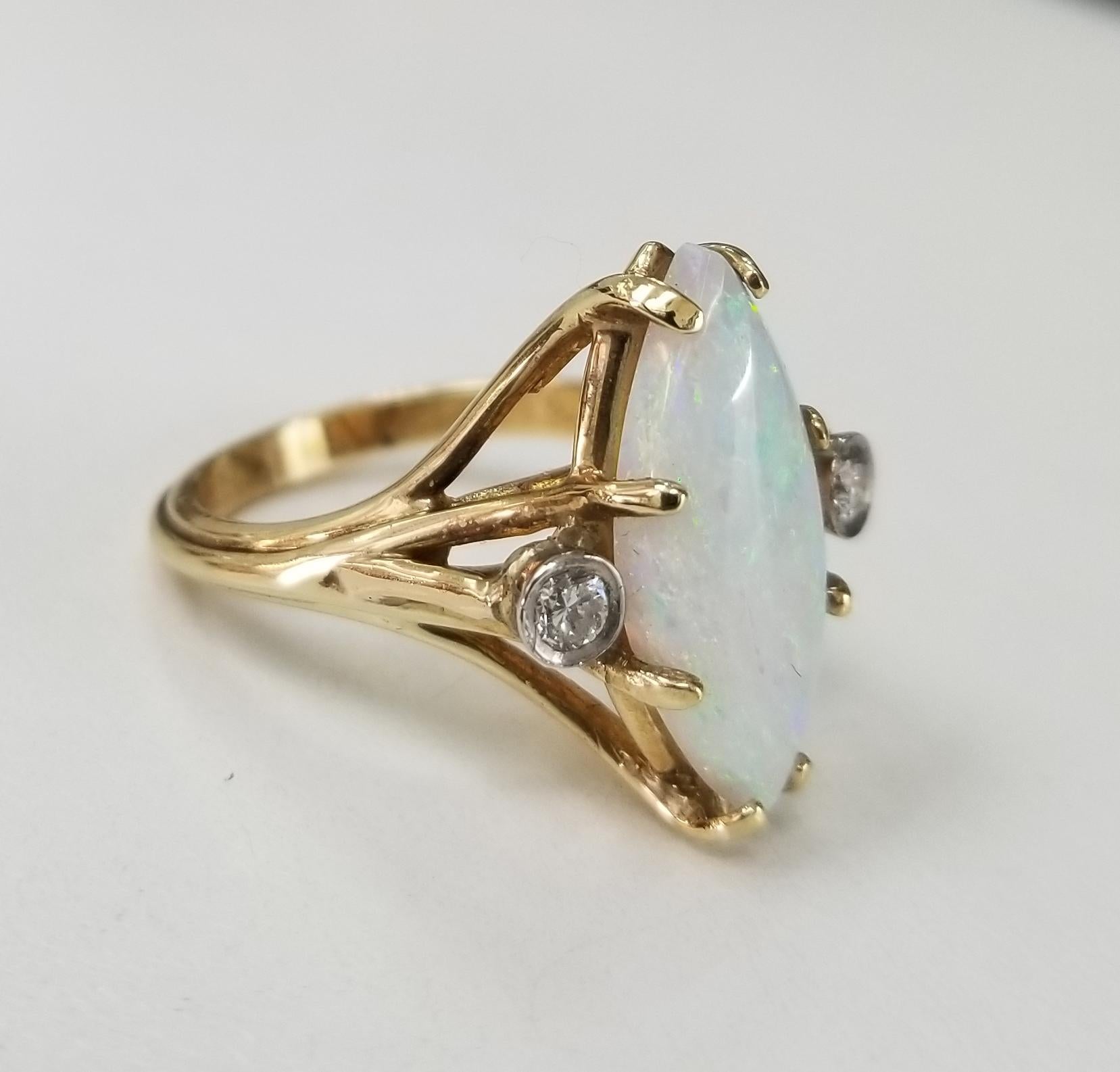 14k yellow gold opal ring, containing 1 marquise cut opal weighing 3.00cts. and 2 round diamonds weighing .15pts.  This ring is a size 6.5 but we will size to fit for free.