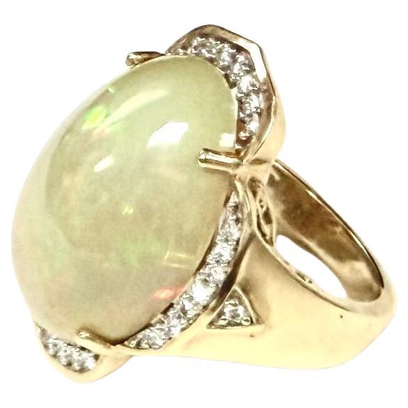 Magnifique bague en or jaune 14k, opale encerclée de diamants.  7,15 grammes TW. Les dimensions de l'opale sont d'environ 13 mm x 20 mm. Environ 8 carats. Marqué 14K. Taille approximative 4,5.