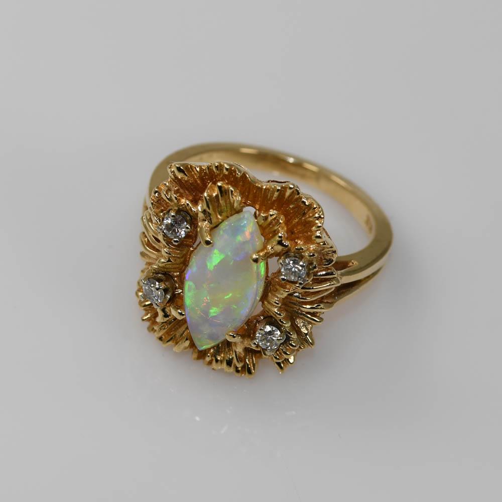 Bague pour dame en opale australienne avec diamants dans une monture en or jaune 14k.
Estampillé 14k et pèse 6,9 grammes.
L'opale est une opale de cristal de forme marquise.
Mesure 13,6 x 6,3 mm.
Sur les côtés se trouvent quatre diamants ronds de