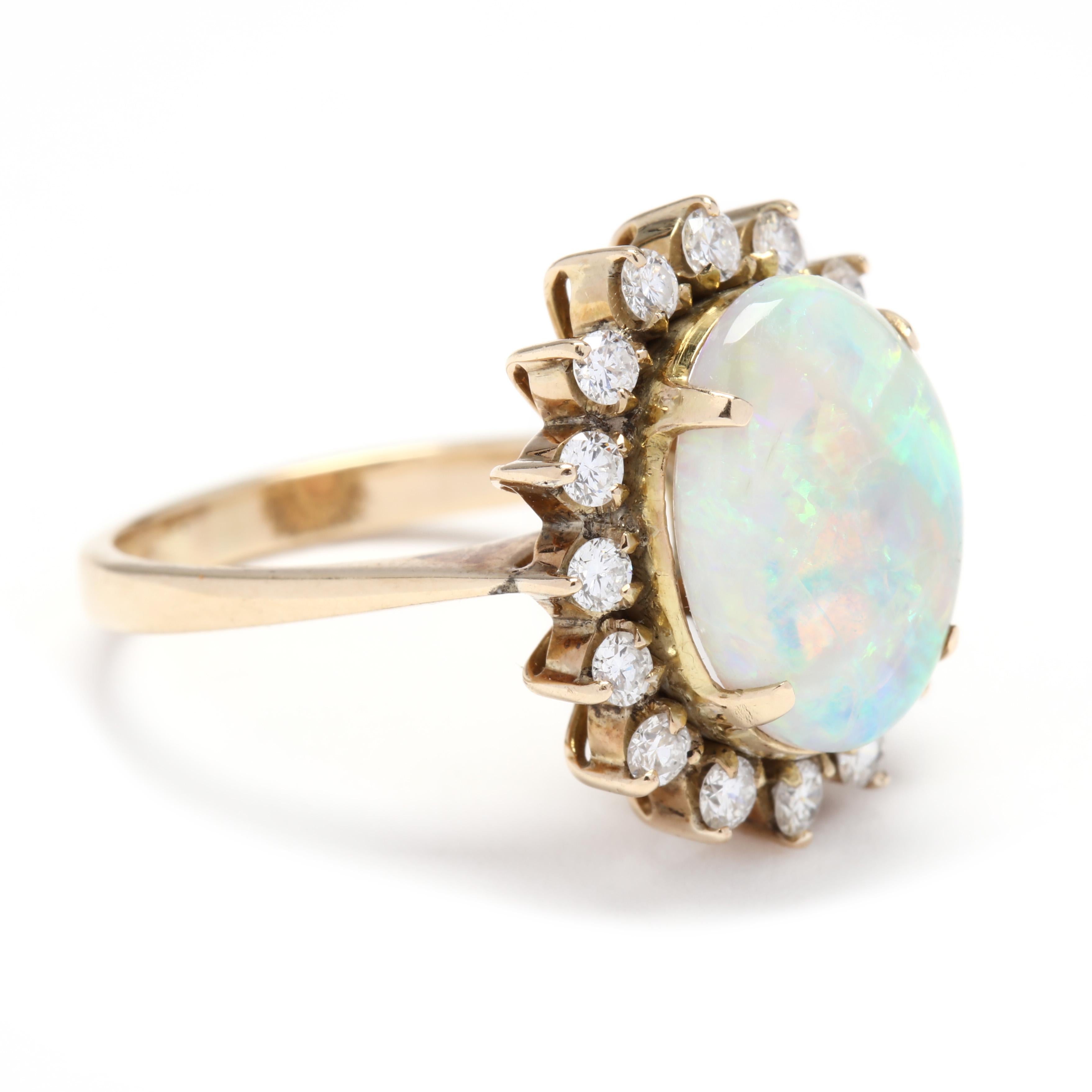 A 14 karat yellow gold, opal and diamond statement ring. This ring features a prong set, oval cabochon opal weighing approximately 3.44 carats surrounded by a halo of full cut round diamonds weighing approximately .56 total carats and with a