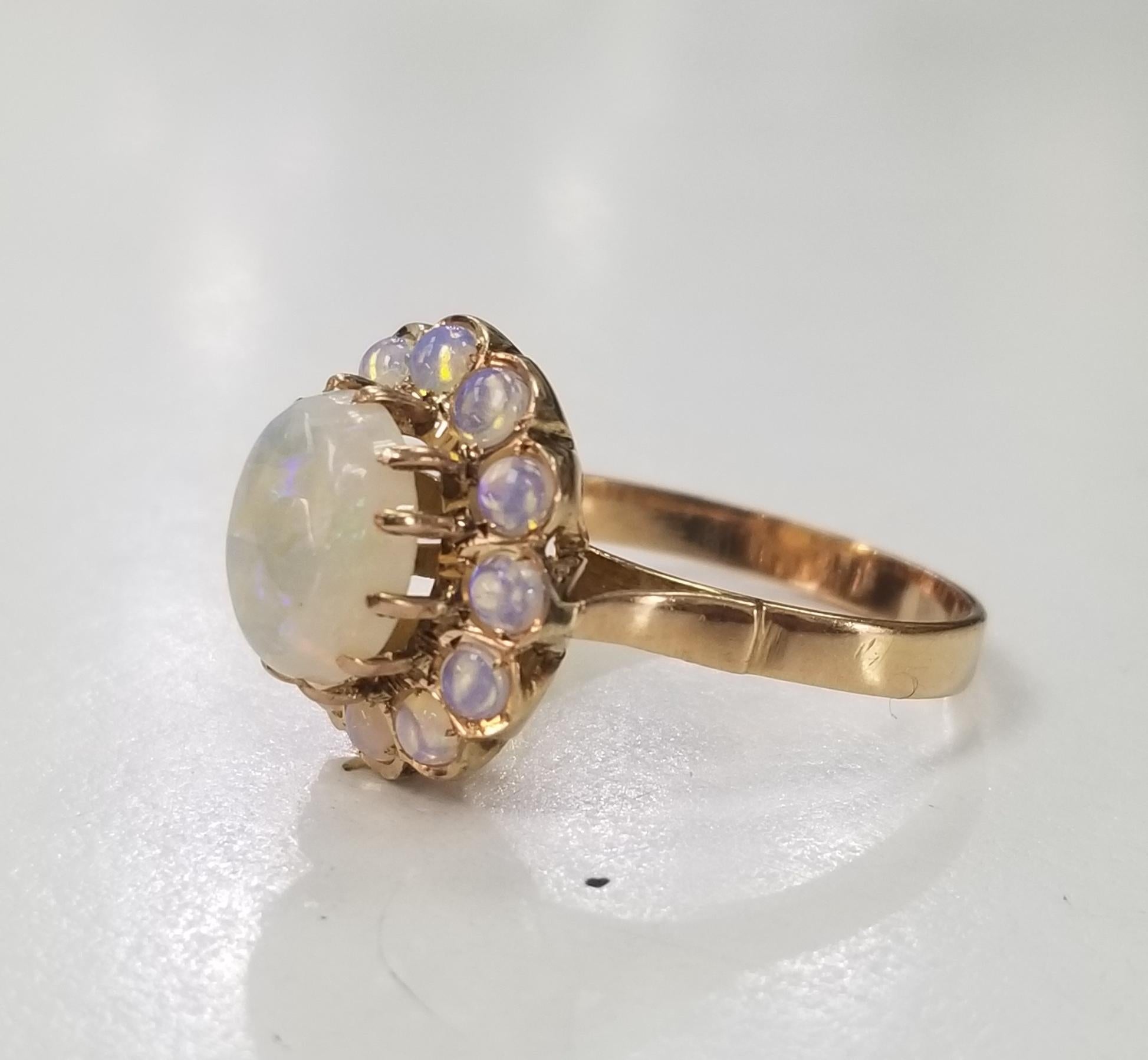 14k yellow gold opal ring, containing 1 oval opal weighing 2.00cts. and surrounded by round opals weighing 1.20cts.  This ring is a size 7.75 but we will size to fit for free.