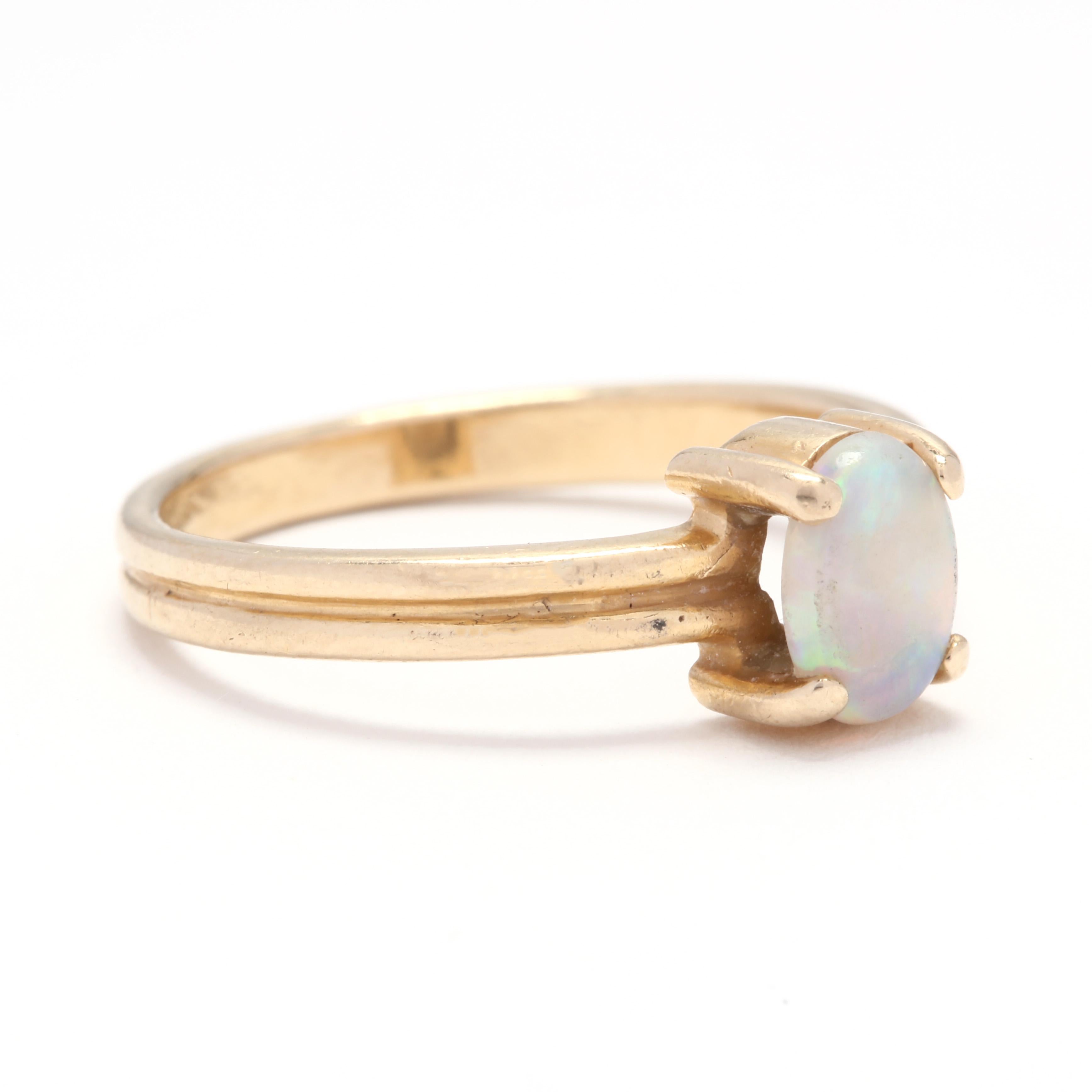 A 14 karat yellow gold and opal solitaire ring. This ring features a prong set, oval cabochon opal set on a ridged band.

Stone:
- opal
- oval cabochon, 1 stone
- 6.97 x 4.96 x 1.88 mm
- approximately .50 carat

Ring Size 6.75

1.79 dwts.

* Please